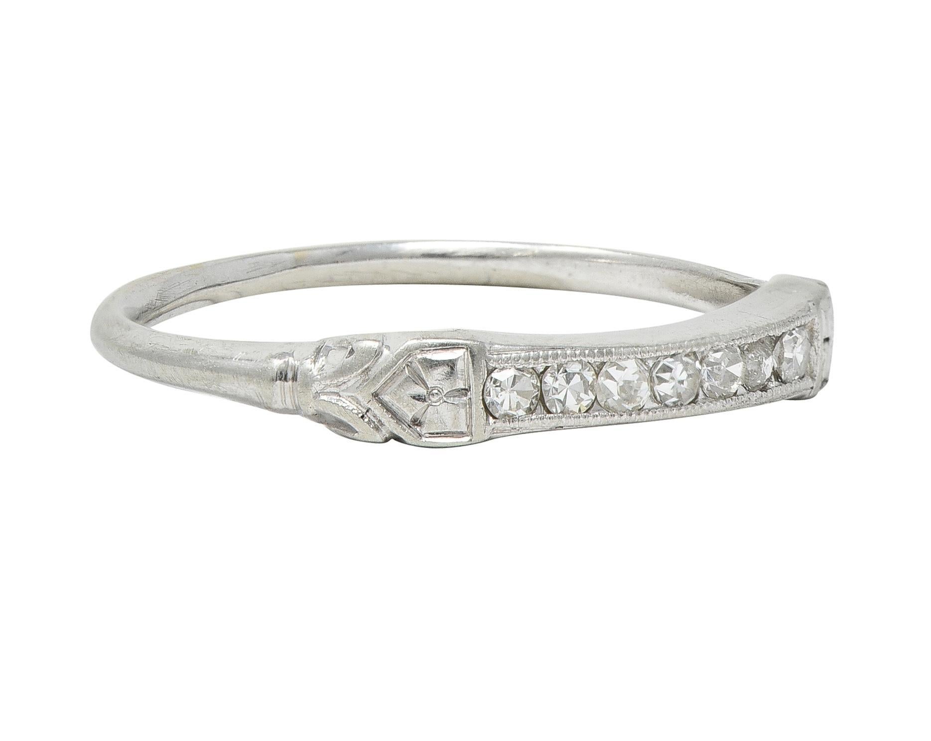 Featuring a row of single cut diamonds channel set east to west 
Weighing approximately 0.14 carat total - eye clean and bright 
Accented by milgrain edges and flanked by engraved shoulders
Depicting orange blossom and volute motifs
Stamped for 18
