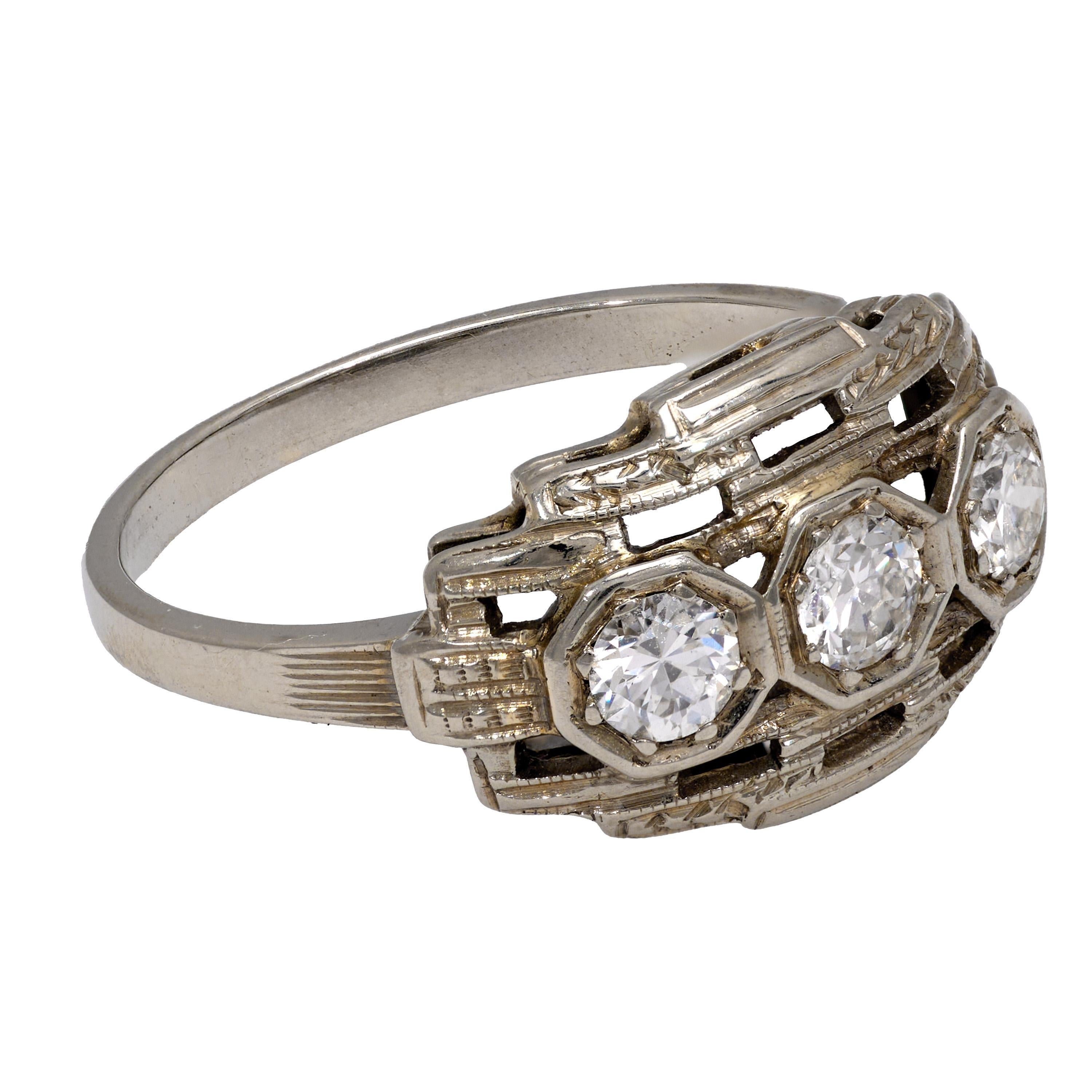 This Art Deco ring from the 1930s is crafted in 18k white gold and features three transitional cut diamonds with a total weight of approximately 0.30 carats. The diamonds are graded G-H color and VS clarity, offering elegant vintage sparkle in a