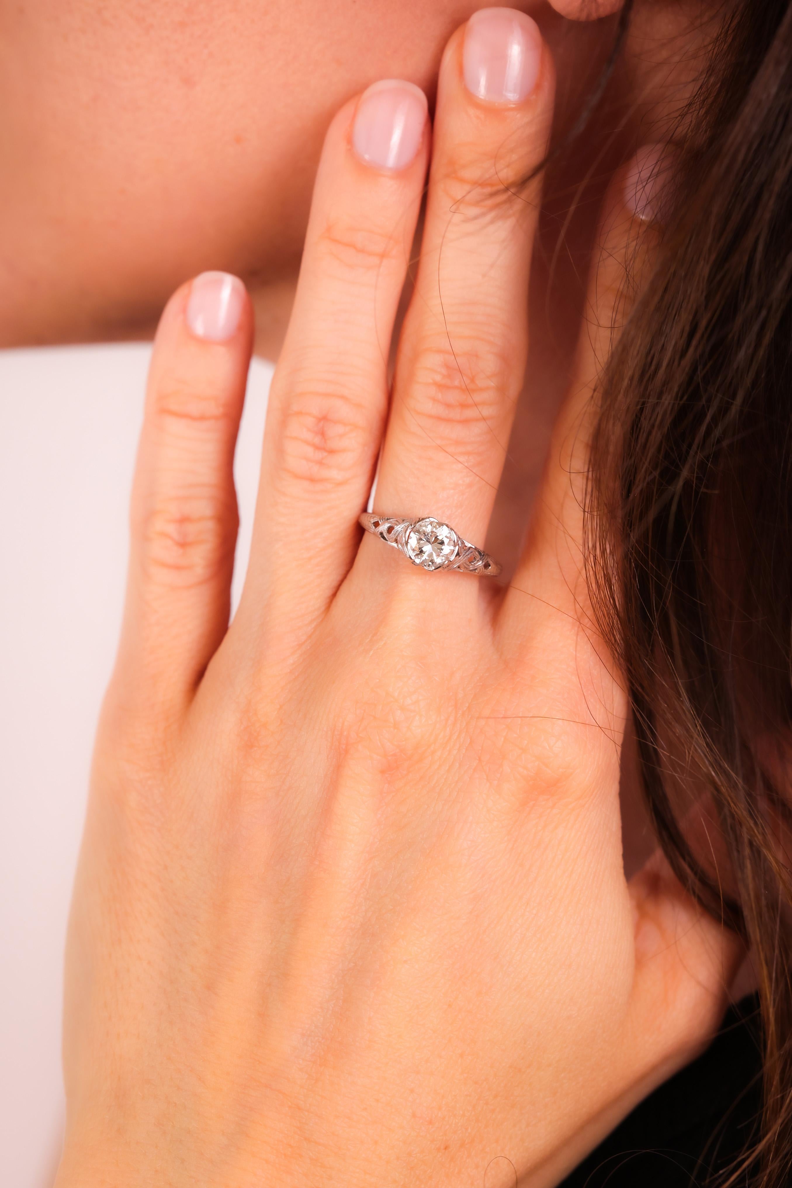 Center Stone: Diamond
Cut: Old European
Weight: Approximately 0.8 Carats
Color: I
Clarity: SI
Metal: 18K White Gold
Era: Art Deco
Circa: 1930s
Hallmarks: 18K Purity Marks
Size: 7 and can be resized
Gram weight: 2.32

This exquisite Art Deco ring