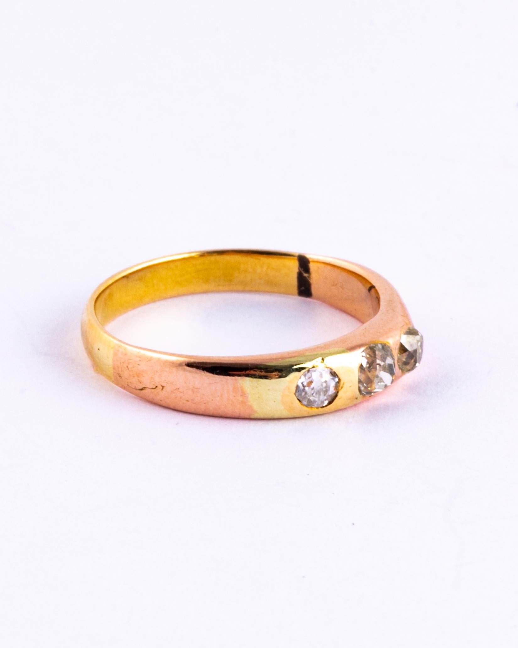 Sitting at the centre of this simple gold band are three diamonds totalling 35pts. The diamonds are old mine cut and have a wonderful bright sparkle. 

Ring Size: L 1/2 or 6 
Band Width: 4mm

Weight: 2.9g