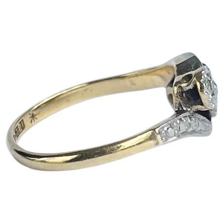 This diamond ring holds three glittering diamonds measuring a total of 11pts. Set in platinum twist illusion settings and ring modelled in 18 Carat gold. The ring also has three diamonds set into the shoulders. 

Ring Size: J 1/2 or 5
Widest Point: