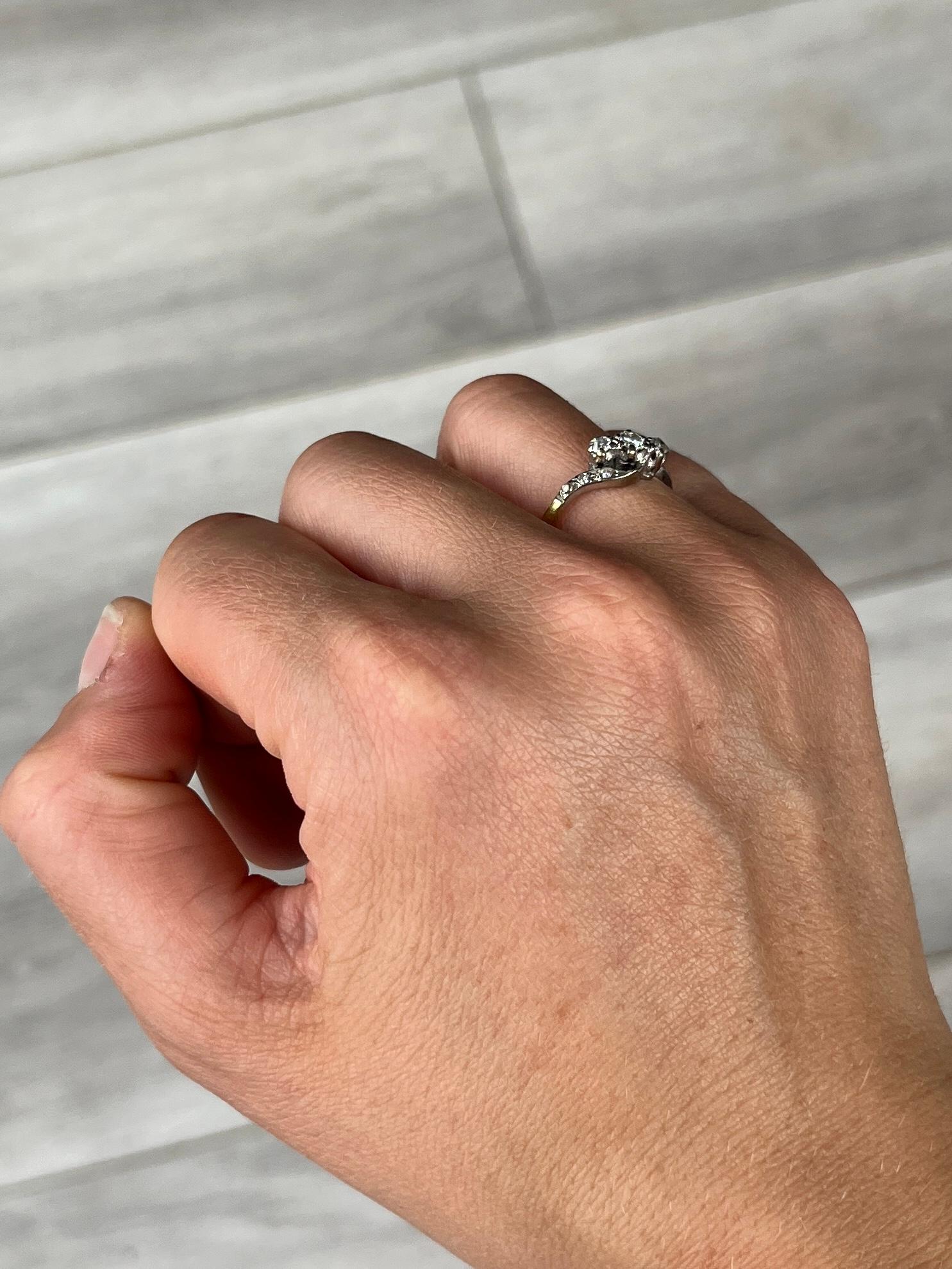 Questo anello di diamanti contiene tre scintillanti diamanti per un totale di 35pt e sulle spalle sono incastonati anche diamanti più piccoli di 2pt ciascuno. Incastonate in montature a spirale in platino e anello modellato in oro 18 carati.