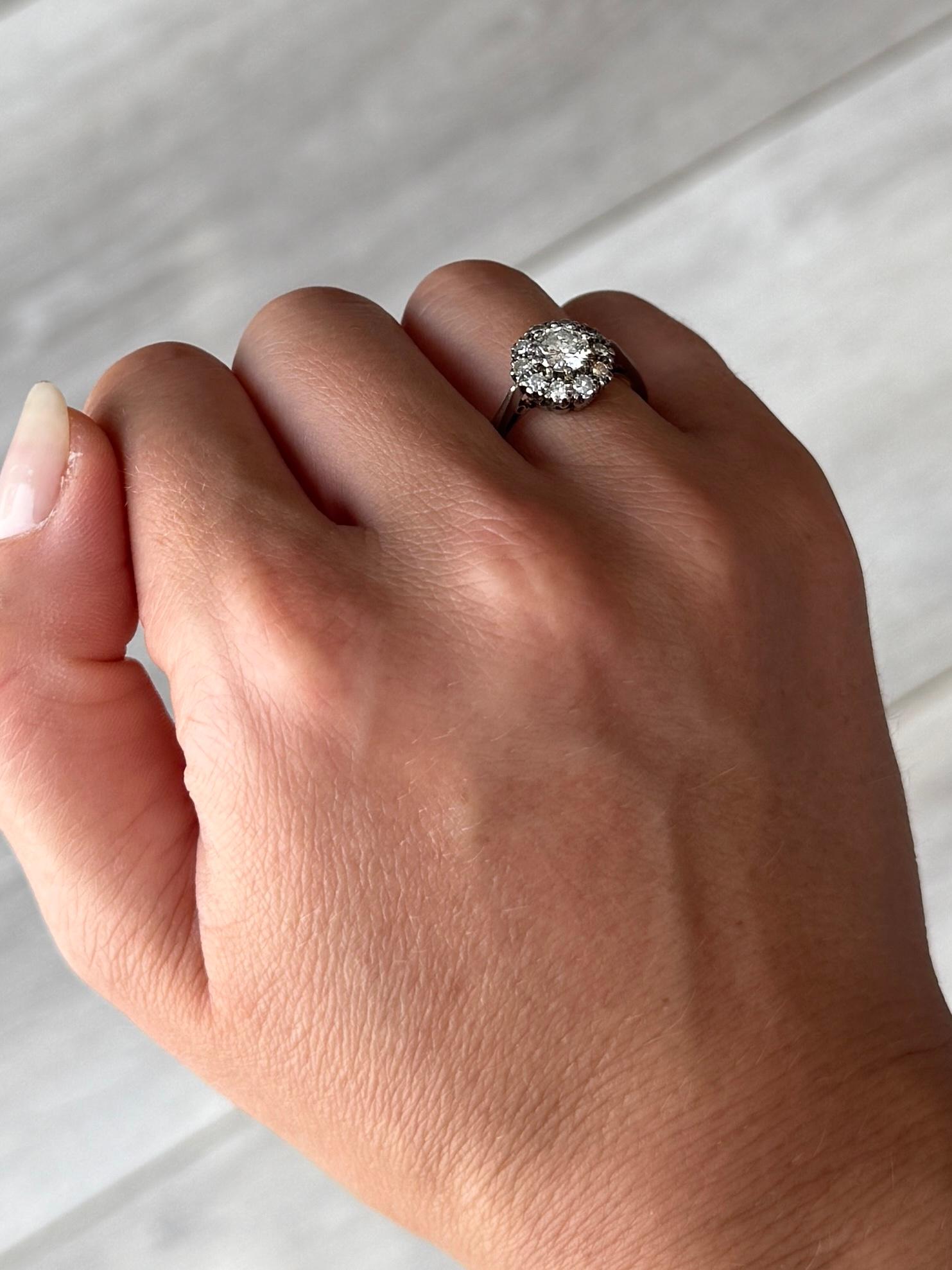 A cluster set with a central diamond measuring 75pts and the diamond total approx 1.25carats. The ring is modelled in 18 carat white gold. 

Ring Size: P 1/2 or 8   
Cluster Diameter: 11mm
Height Off Finger: 7mm

Weight: 3.9g
