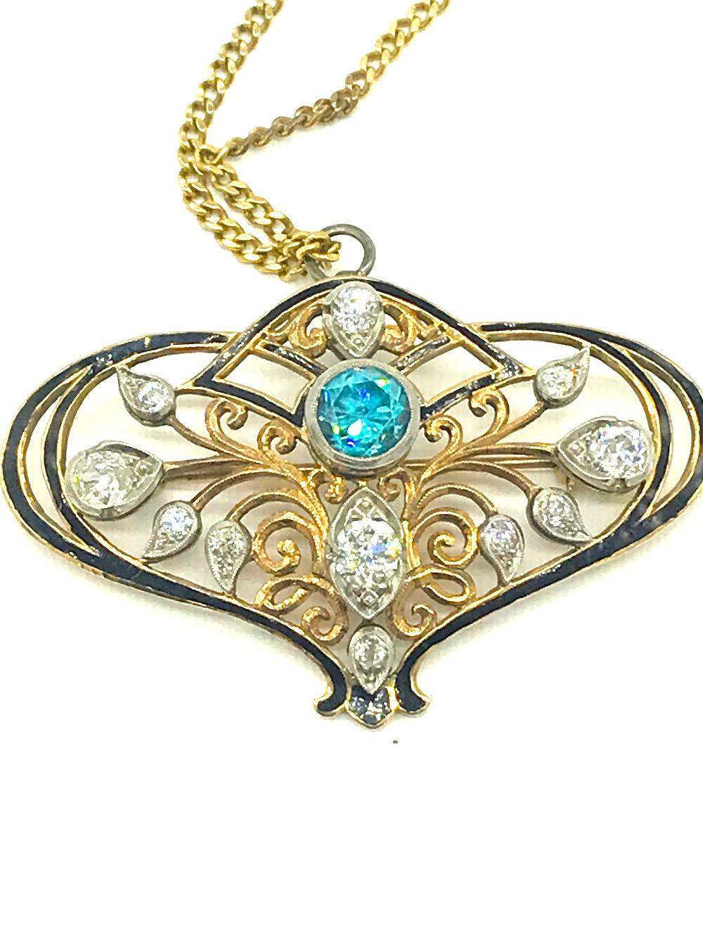 Art Deco Style pendant features European Cut diamonds set with a centered blue zircon.  The pendant measures
36 x 57 mm diameter and is accented with black enameled highlighting.  A lovely and large style pendant can be worn as a pin also as it is