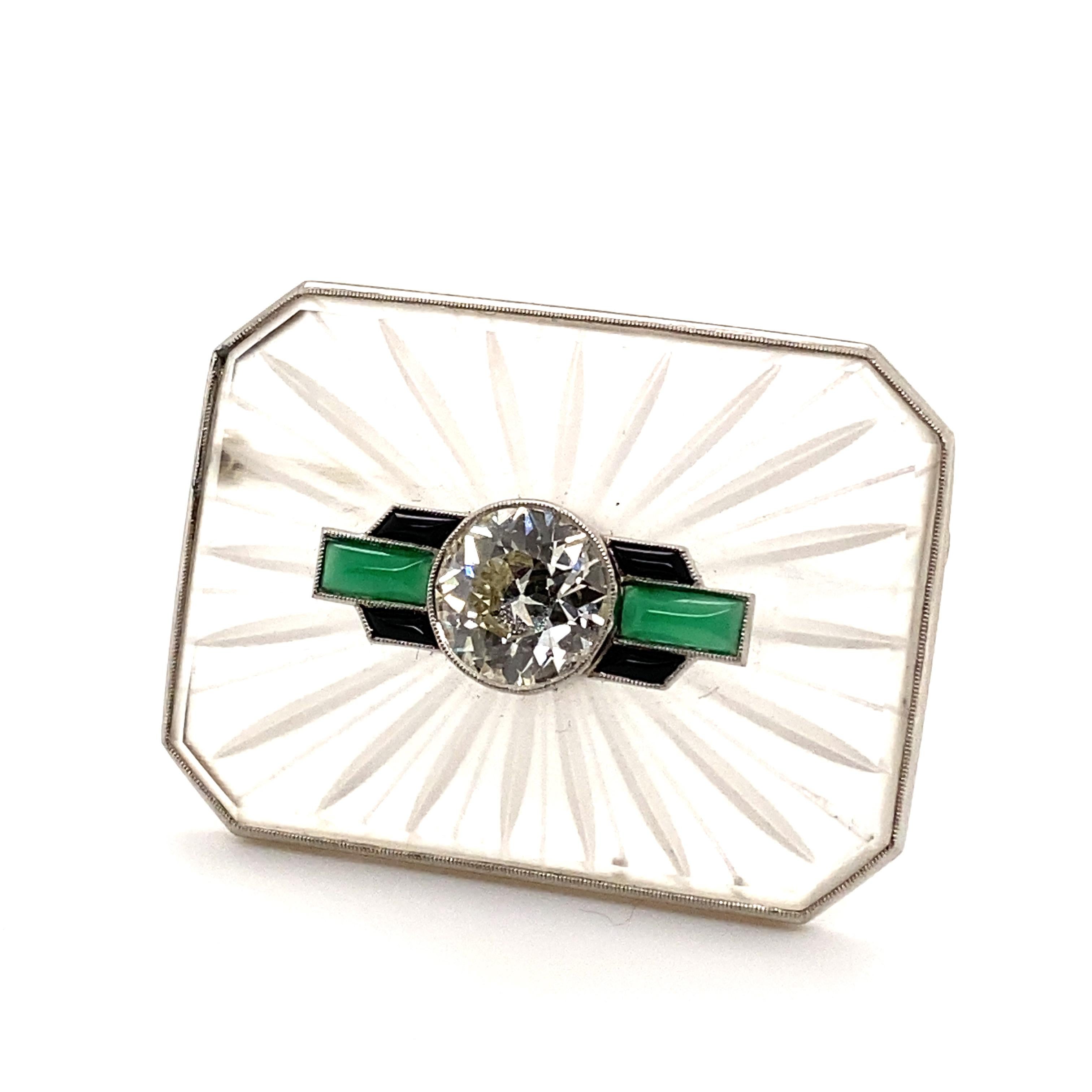 Handmade in platinum 950 and with decorative millegrain settings, this beautiful brooch combines various very typical elements for Art Deco jewellery.

The basic element is an octagonal-cut rock crystal quartz, which is engraved radially on the