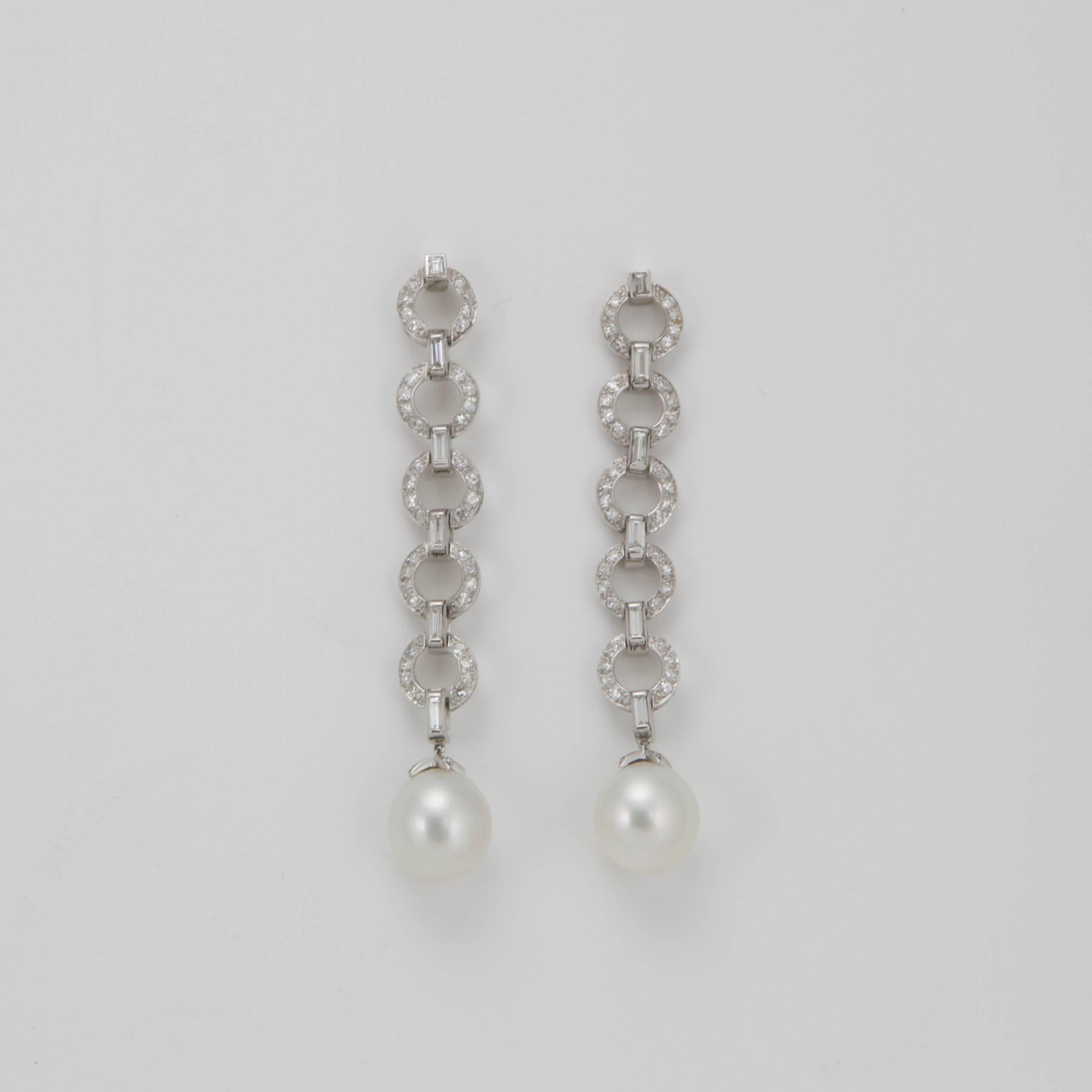 Each composed with five circles set with round diamonds retained by six baguette diamond suspending a cultured pearl.
Total weight diamond almost 3.2 carats. 
Size of CULTURED PEARL approximatly 13.6 x 14.5 mm and 13.9 x 14 mm. 
Made in France