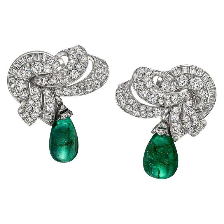 Art Deco earrings, featuring a cluster of round and baguette-cut diamonds suspending a pear-shaped emerald bead drop, made of platinum.

Diamonds altogether weighing ~7.40 total carats
Two emeralds weighing ~10.00 total carats
1.35
