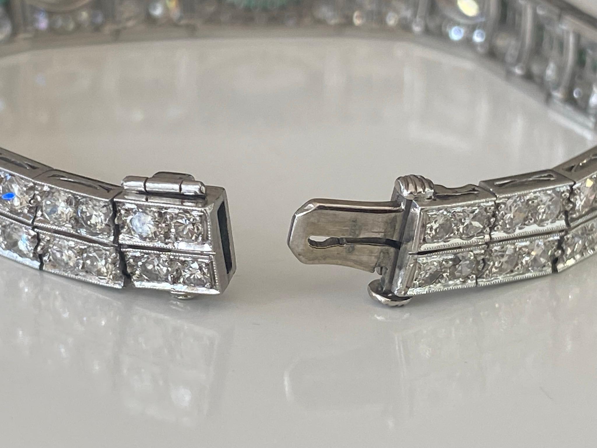 Crafted in the 1920s from platinum, this stunning Art Deco bracelet features three bezel-set marquise diamonds (the center stone measures 0.60 carats) surrounded by an array of glistening Old European cut diamonds and accented with calibre emeralds