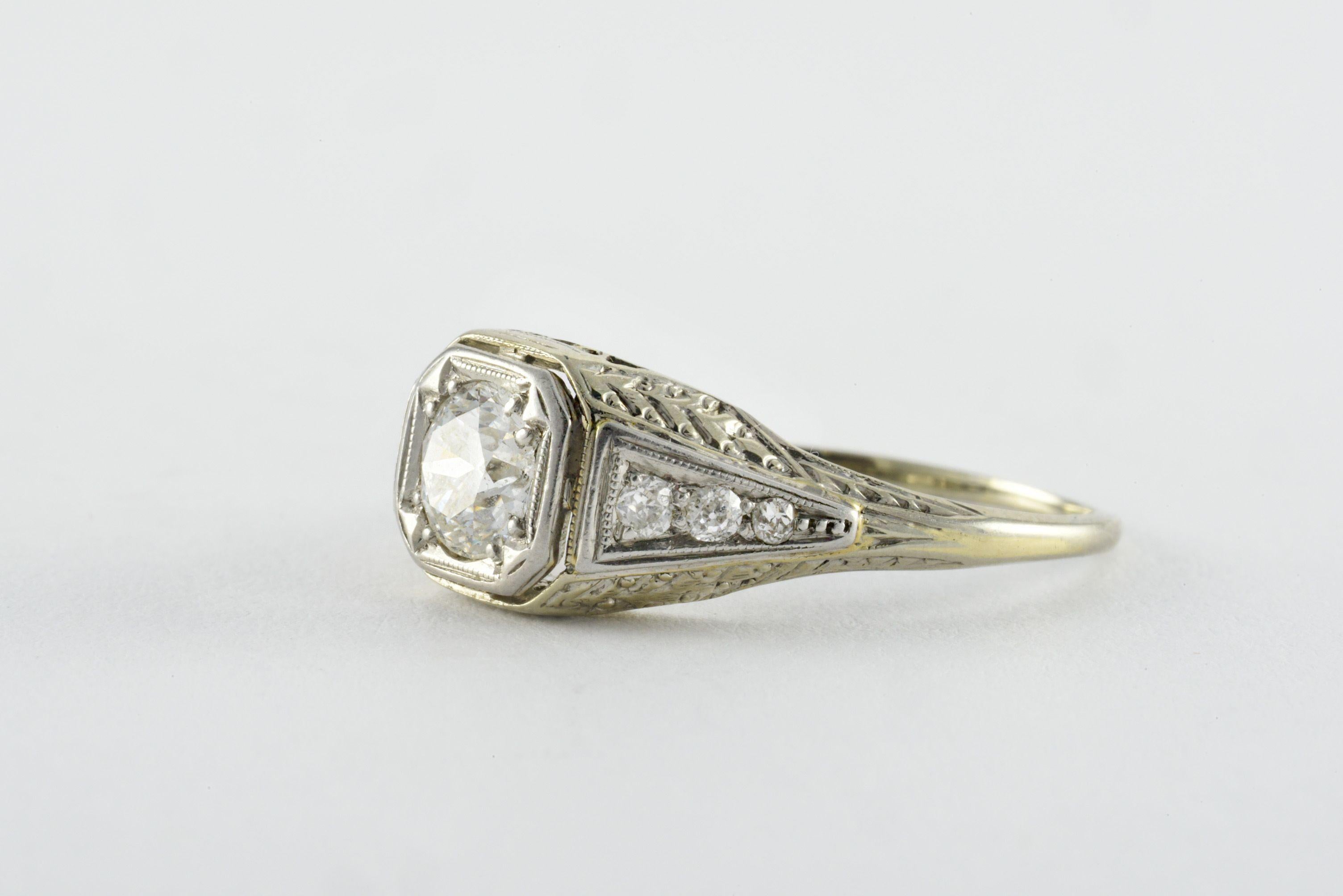 Crafted in the 1920s from 14-18kt white gold, this Art Deco band features an Old European cut diamond measuring approximately 0.65 carats, F color, I1 clarity and embellished with six smaller Old Mine cut diamonds on the shoulders totaling