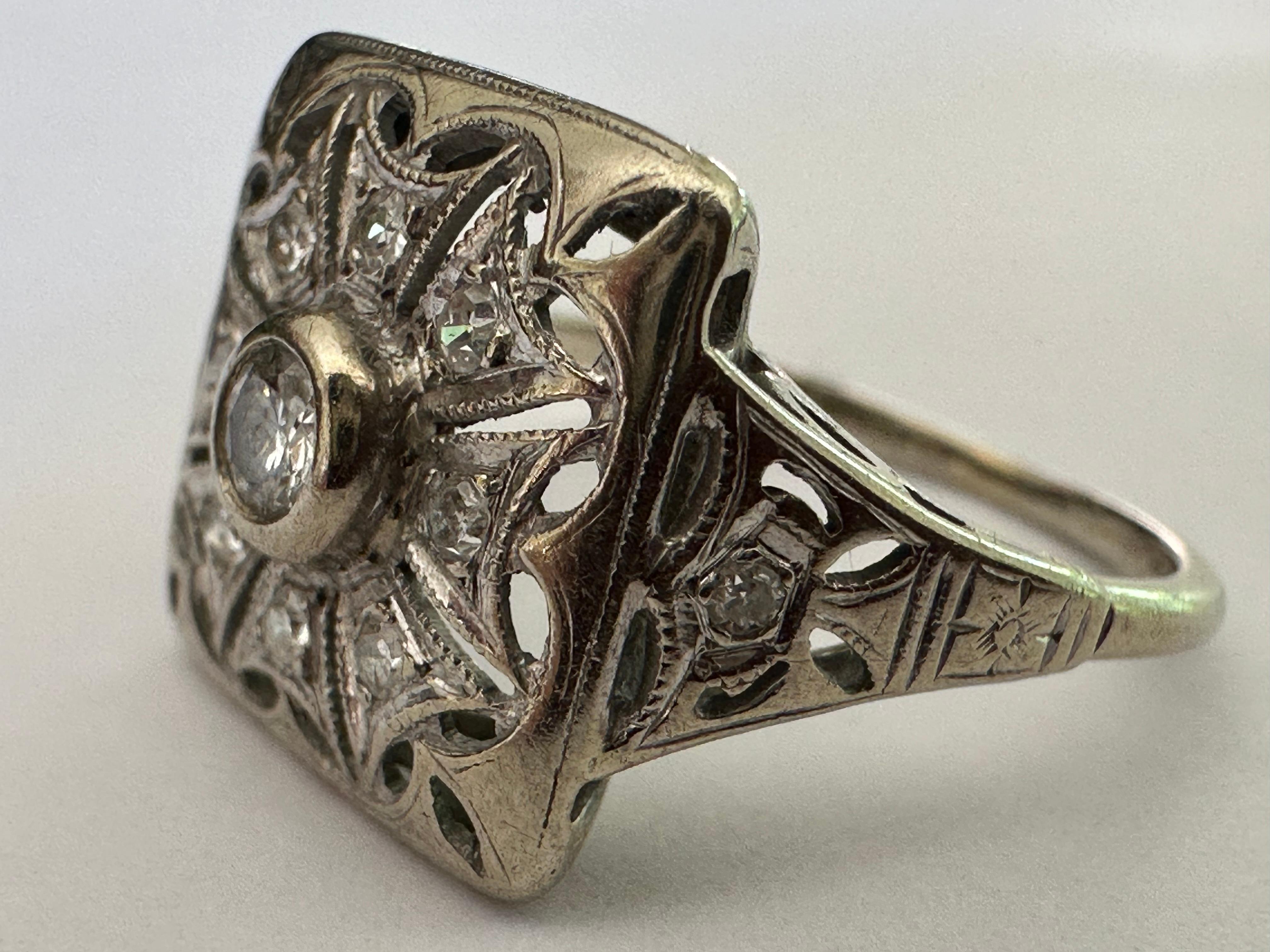 Realizzato negli anni '40 in oro bianco 10K con un intricato design a filigrana, questo splendido bracciale è impreziosito da un diamante di taglio europeo al centro di circa 0,12 carati, di colore H e purezza SI2, e da dieci diamanti singoli a