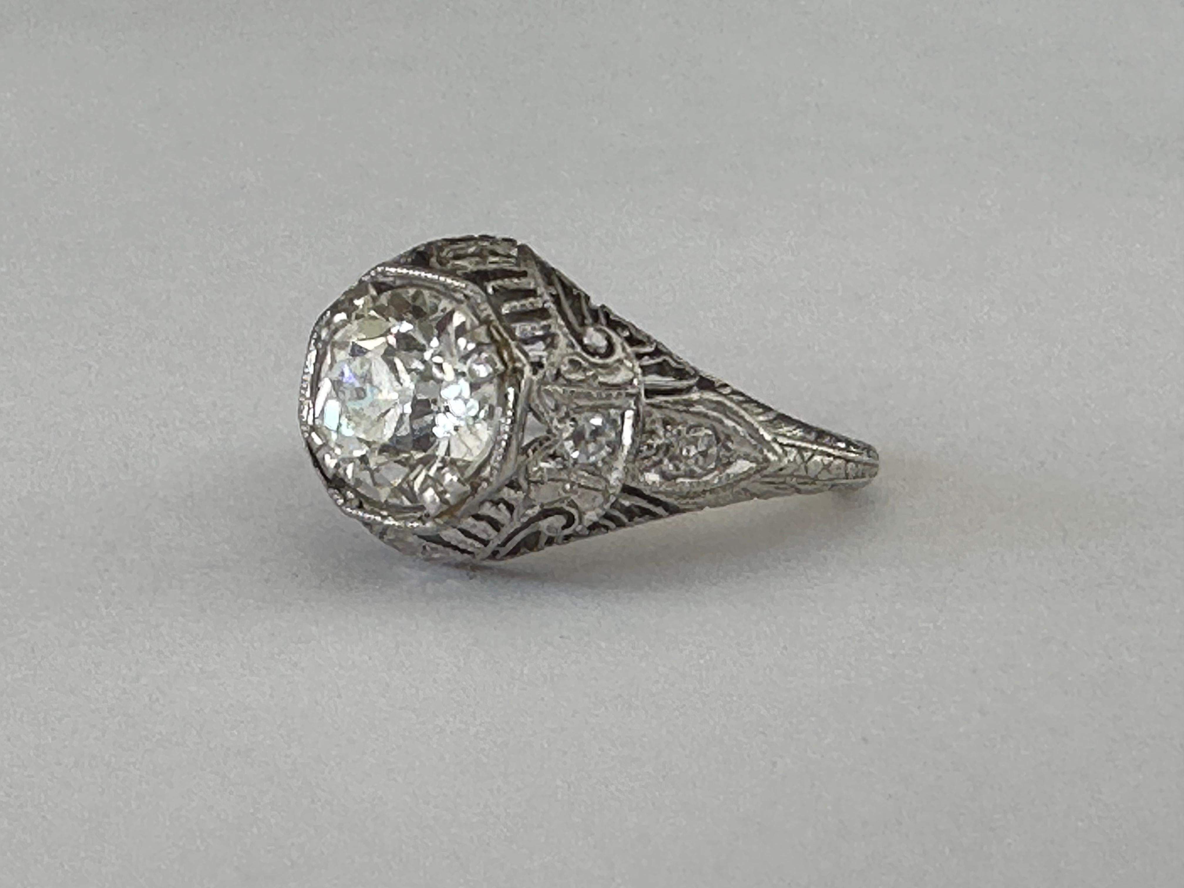 This stunning Art Deco ring handcrafted from platinum is designed around an Old European cut diamond center stone measuring approximately 1.00 carat, H-I color, SI clarity and accented with four single cut diamonds totaling approximately 0.05 carats