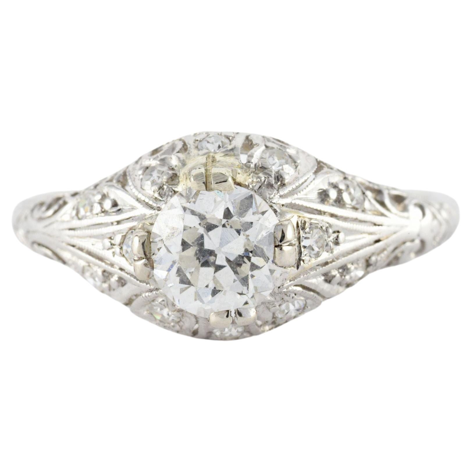 Crafted in the 1920s from platinum, this Art Deco gem features an intricate filigree dome crowned with a bold Old European cut diamond measuring approximately 0.76 carats, F color, VS2 clarity and accented with eleven small single cut diamonds