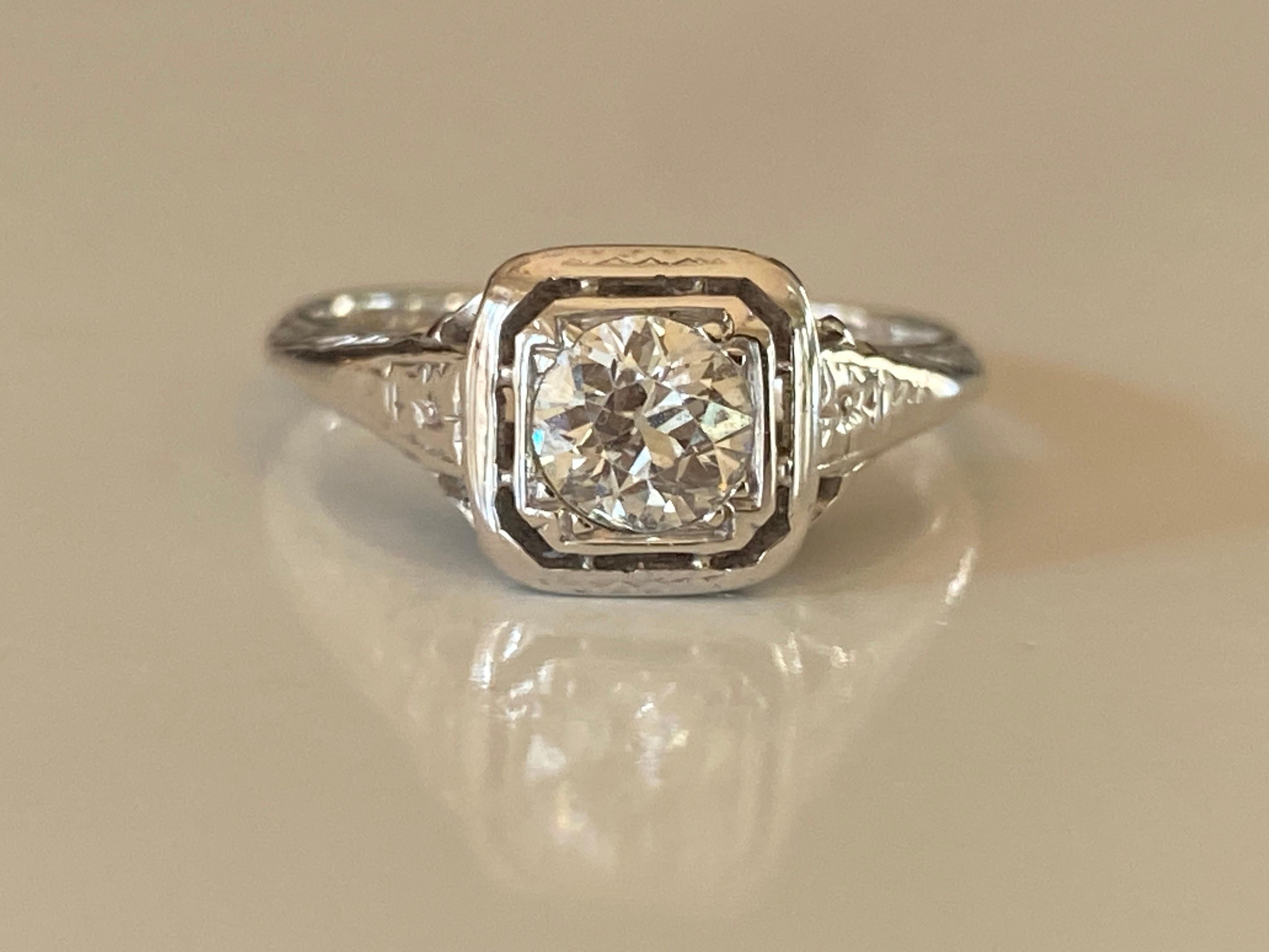Fabriquée dans les années 1920 en or blanc 18 carats, cette remarquable bague solitaire Art déco est ornée d'un diamant de taille européenne d'environ 0,50 carat, de couleur I-J et de pureté VS, et d'un fin filigrane.  