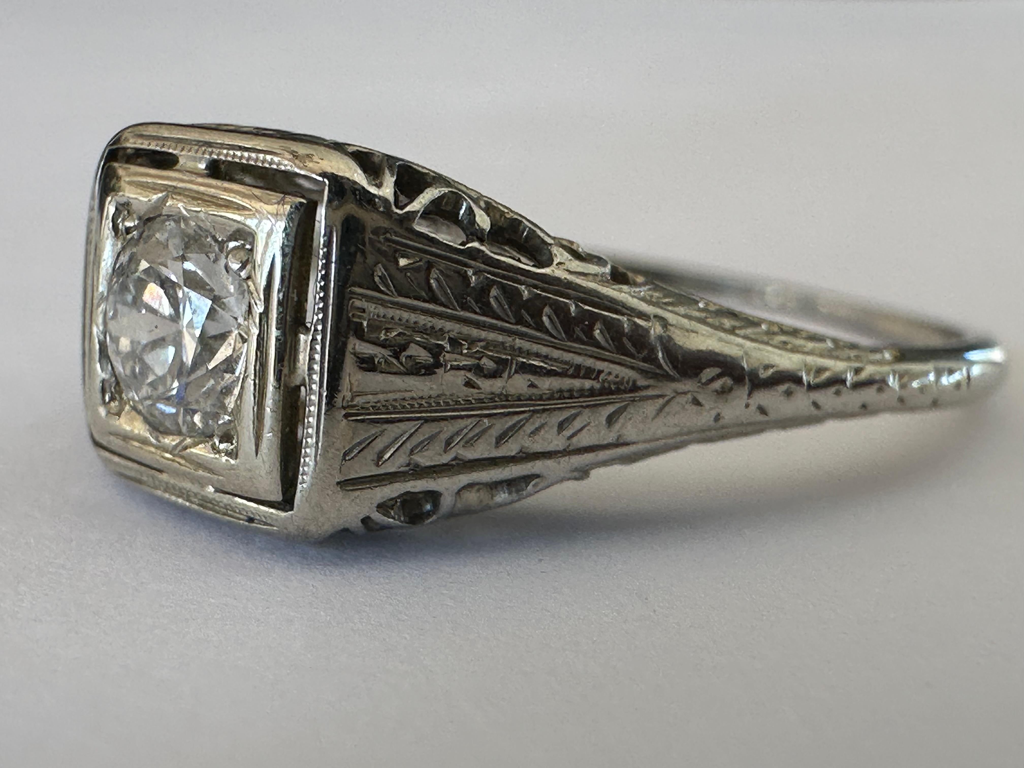 This striking Art Deco band is meticulously crafted from 18k white gold with fine filigree details and set with an Old European cut diamond measuring approximately 0.28 carats, FG color, VS2 clarity. 
