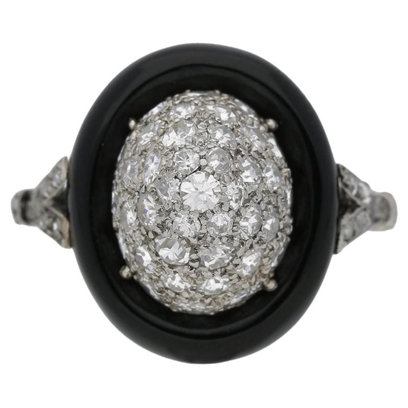 Art Deco diamond and onyx cluster ring. Set to centre with thirty nine round old cut diamonds in open back grain settings with a combined approximate weight of 1.00 carats, further set with twelve round rose cut diamonds in open back grain settings