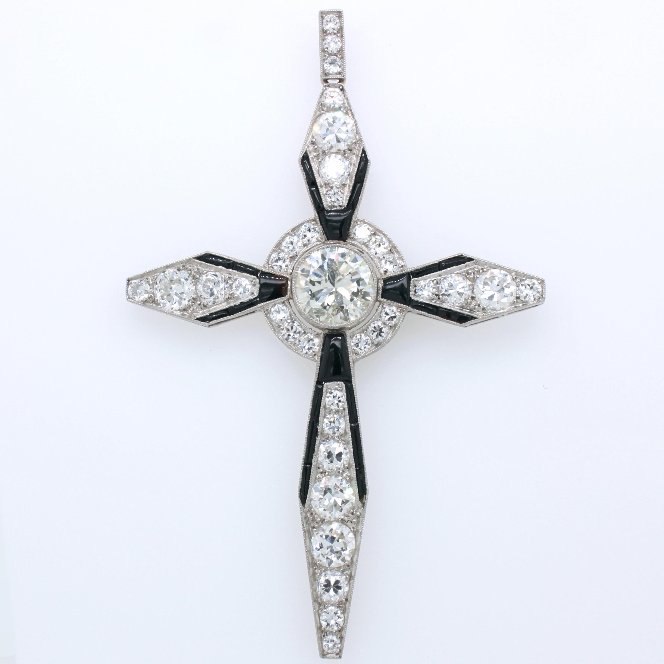 A unique and spectacular Art Deco diamond and onyx cross pendant, ca. 1920s. The big centre diamond weighs approximately 2.1 carats (J/K colour and SI/PK clarity). It is surrounded by a halo of smaller diamonds. The design of each of the cross arms