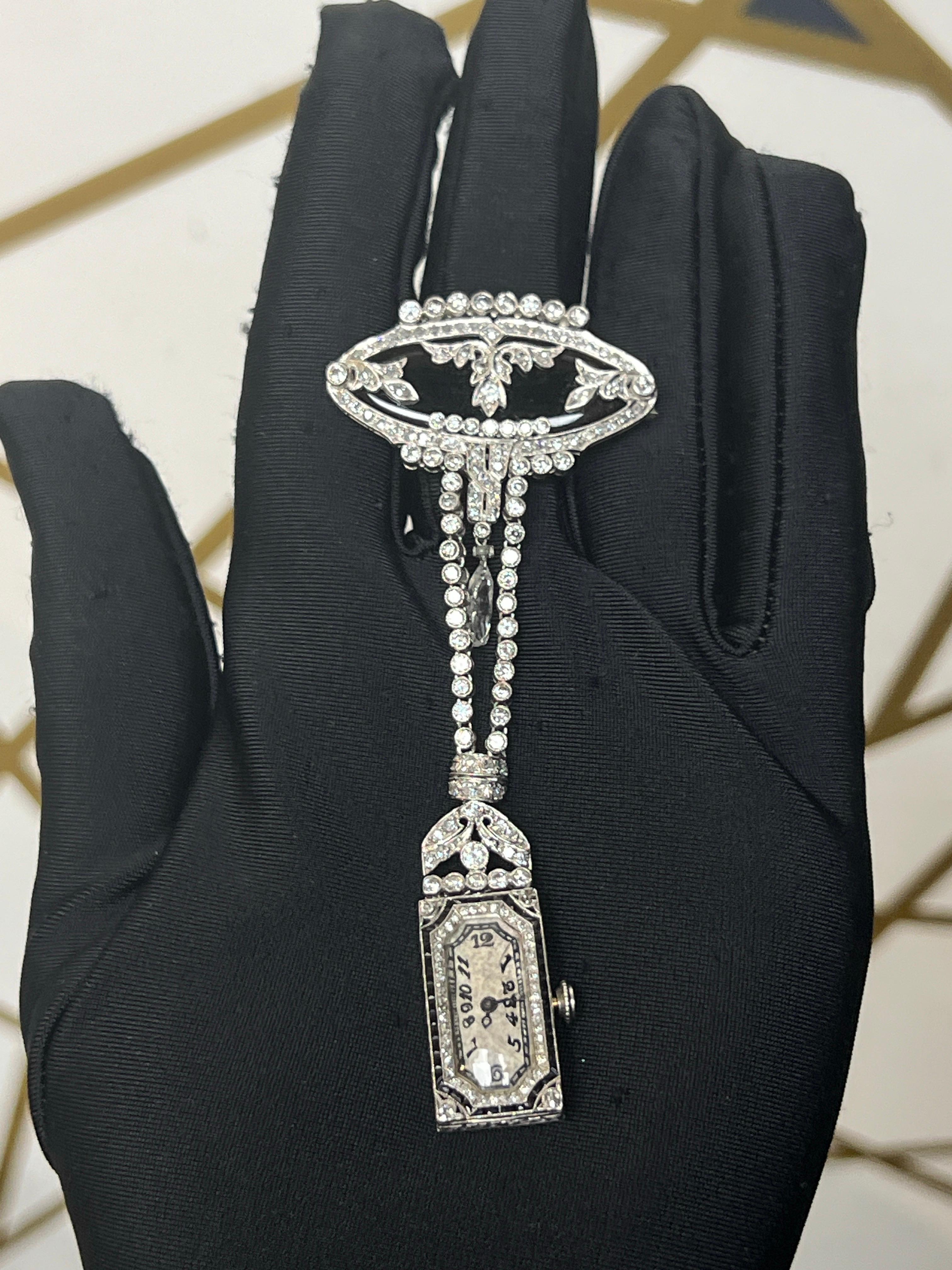 Art Deco Diamant und Onyx Ansteckuhr

Eine Reversuhr, die an einer rautenförmigen Onyxnadel und einer Diamantkette hängt. Zwischen den beiden Diamantketten befindet sich ein hängender Briolette-Diamant. 

Ungefähres Diamantgewicht: 3,15