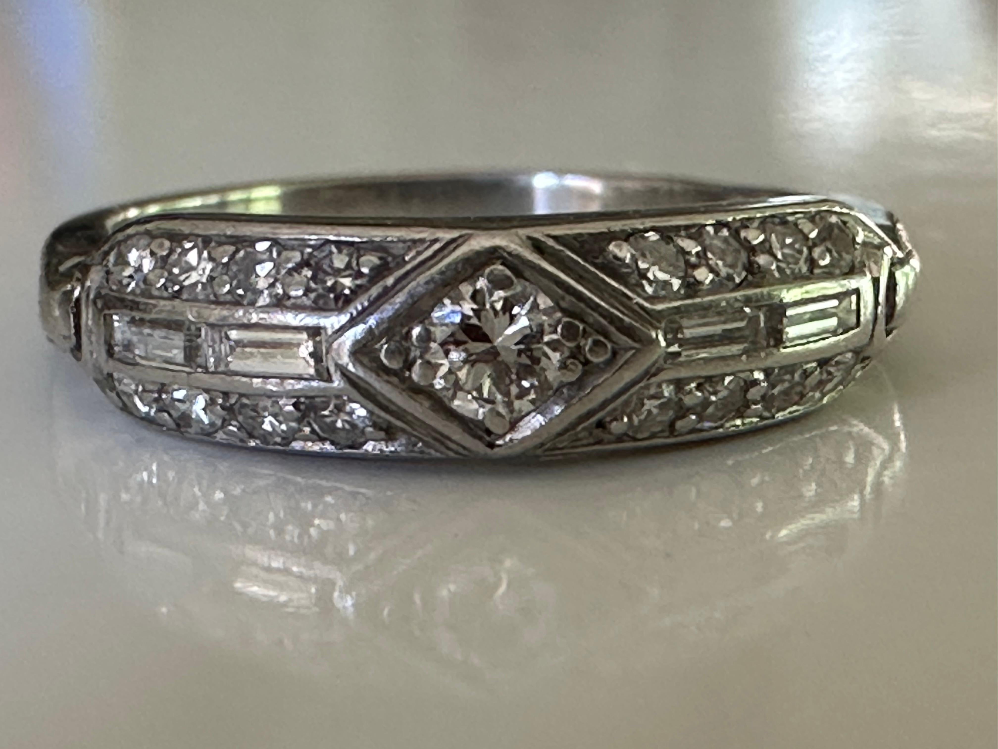 This classic Art Deco band features a 0.03-carat Old European cut diamond center stone accented by sixteen single cut diamonds F color, VS clarity and four baguette diamonds. The diamonds total approximately 0.25 carats. Set in platinum. 