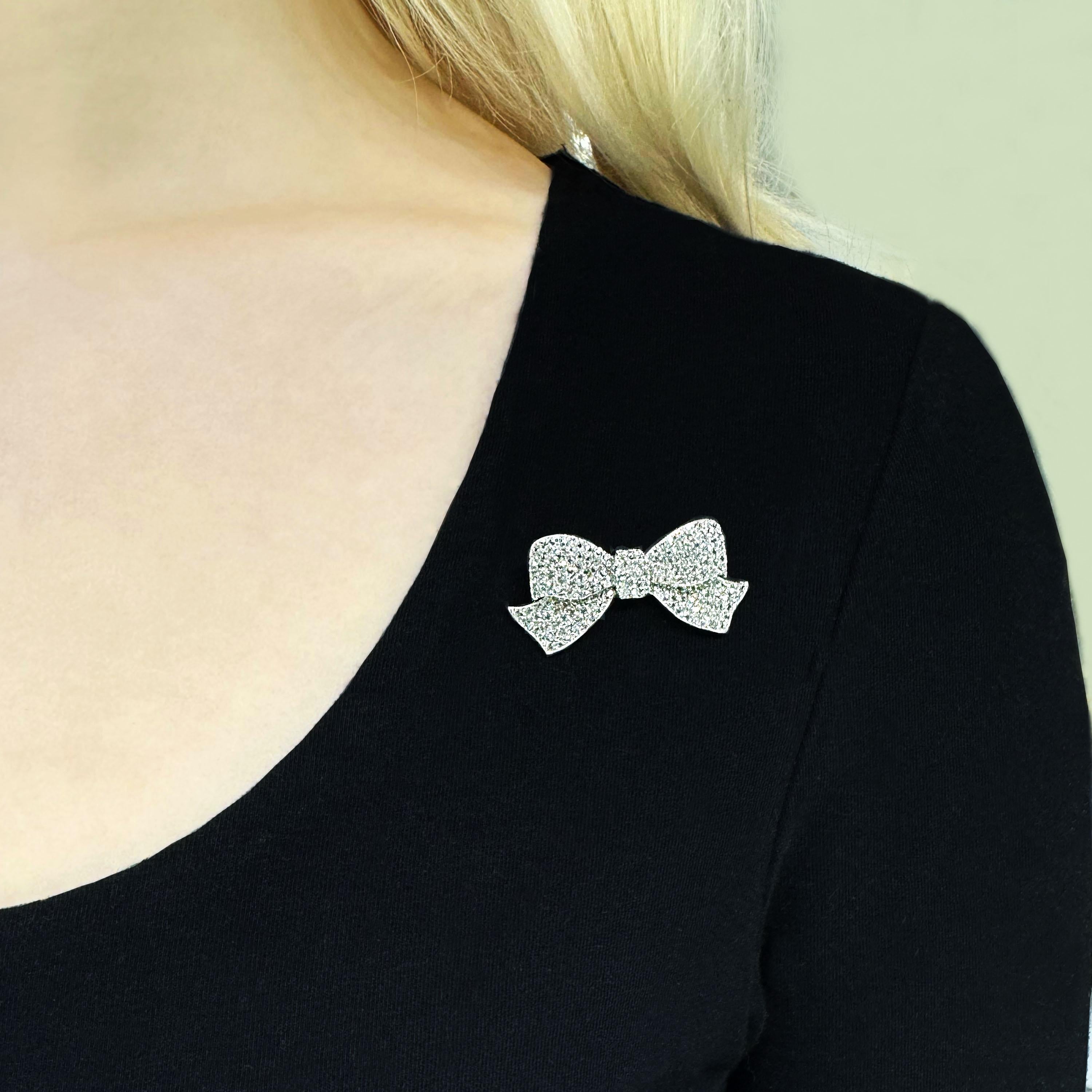 An Art Deco diamond and platinum bow brooch, finely pavé set with old style eight-cut diamonds, with cheneered gallery, mounted in platinum, with a white gold pin and roller catch, numbered, circa 1925. Estimated stone weight 2.91 carats.