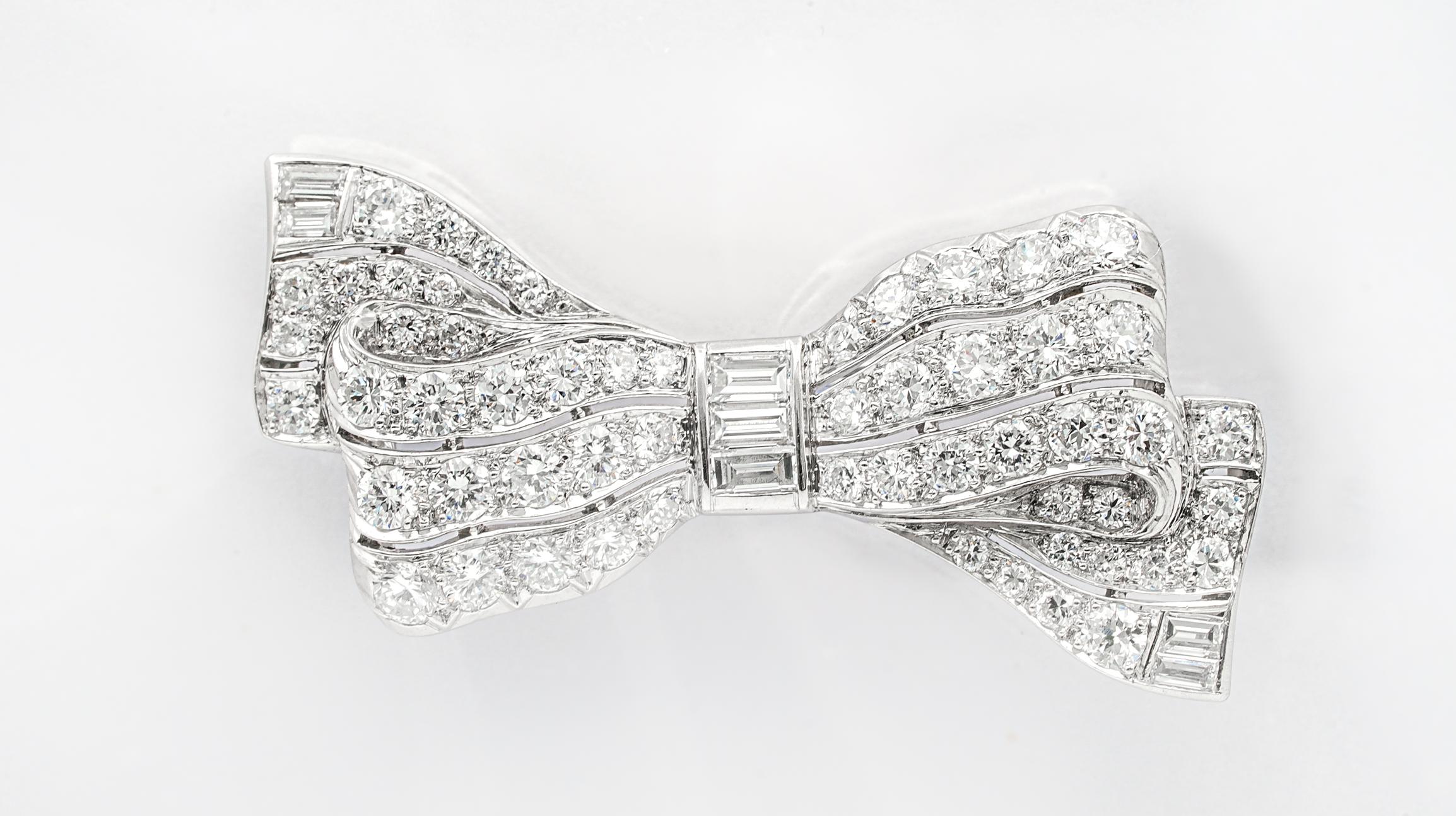 Art Deco Diamond Bow pin from the 1930's finely crafted in platinum with 56 bead set round brilliant cut diamonds and 7 straight baguette diamonds approximately 2.60 carats total weight ranging from H-I color , Fine VS clarity.
Very detailed, well