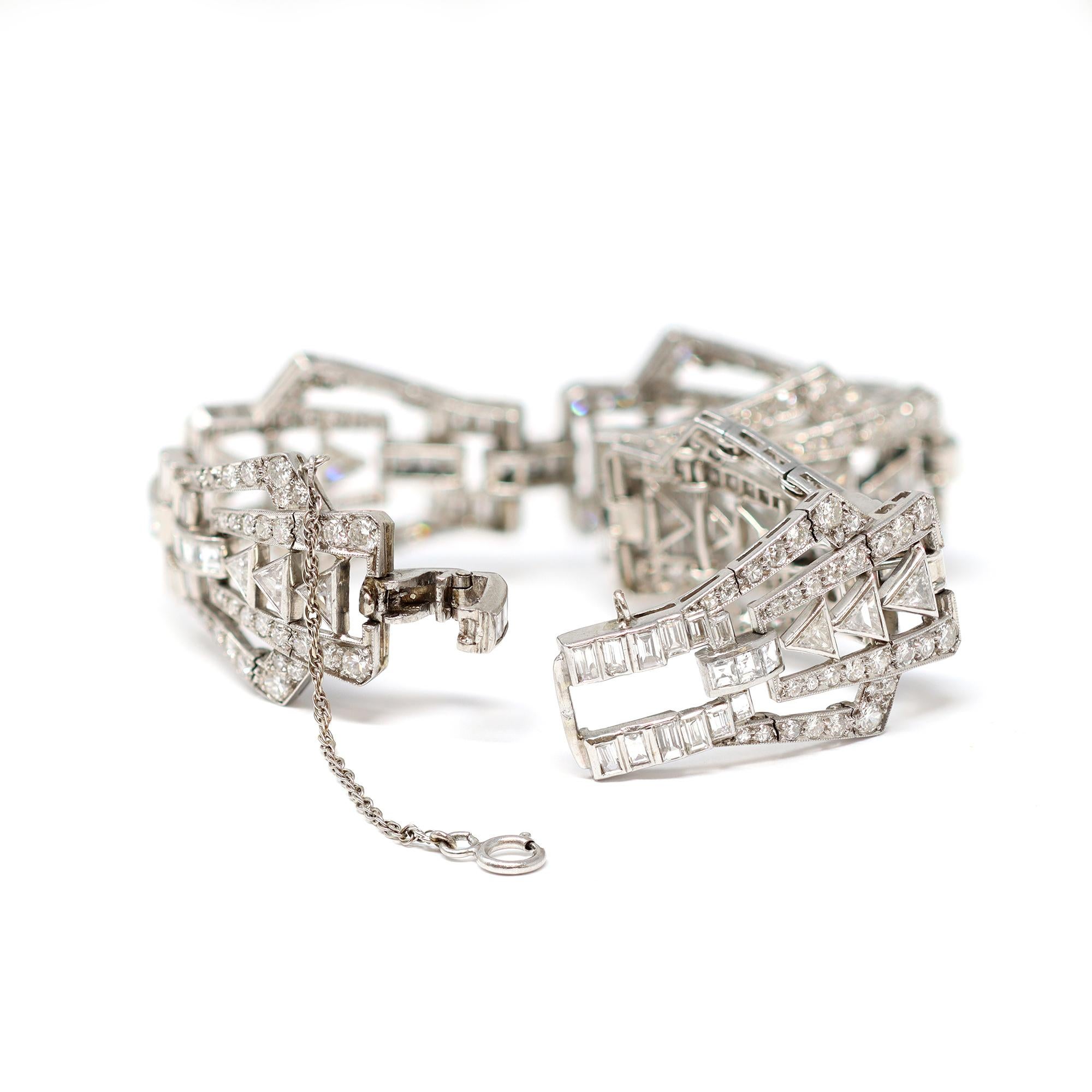 Art Deco platinum and diamond bracelet, designed as a series of openwork geometric links set throughout with various-cut diamonds weighing approximately 9.00 carats, GH color VS clarity. The gross weight is 37.2 grams, length 7 ⅛ inches, width ¾