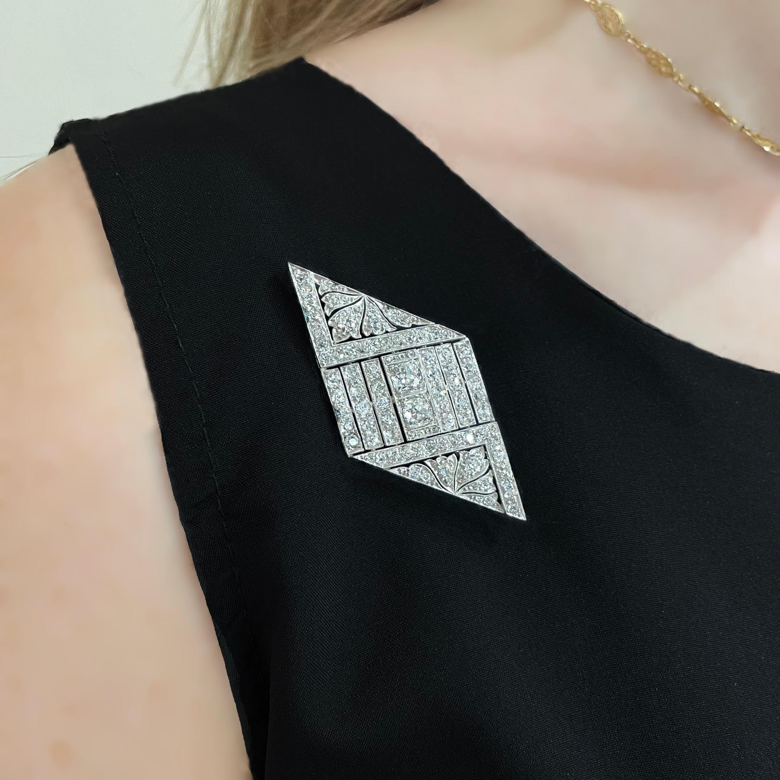 An Art Deco plaque brooch, with a rhombus-shaped outline and a geometric and foliate openwork design, set with old brilliant-cut diamonds, weighing an estimated total of 4.50 carats, with millegrain edges, mounted in platinum, with a pin and 'C'