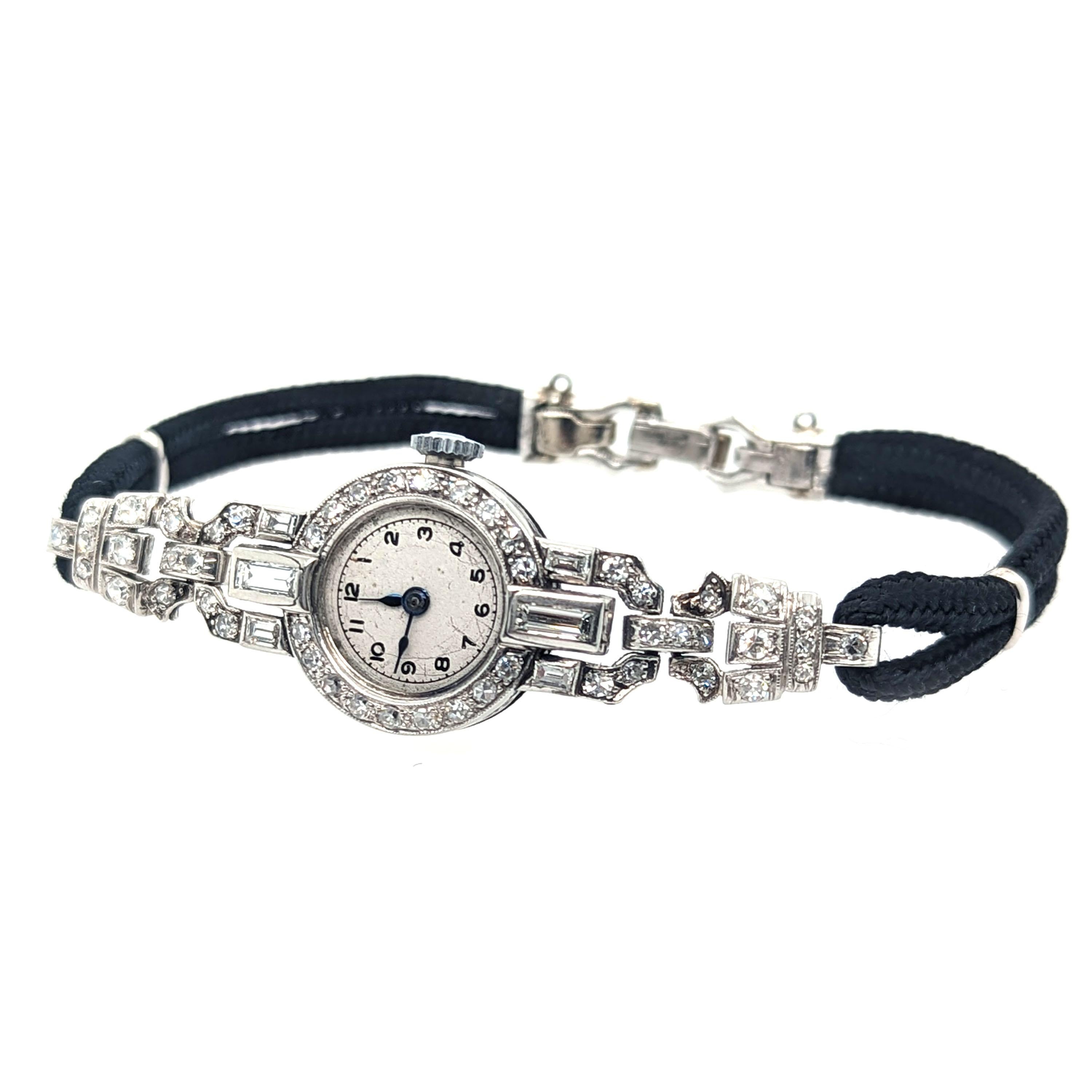 An Art Deco diamond and platinum cocktail wristwatch, with a white, round dial, with black Arabic hand painted numerals, within a ring of minute markers, with black enamelled hands, with an eight-cut diamond set surround, with millegrain edges, with