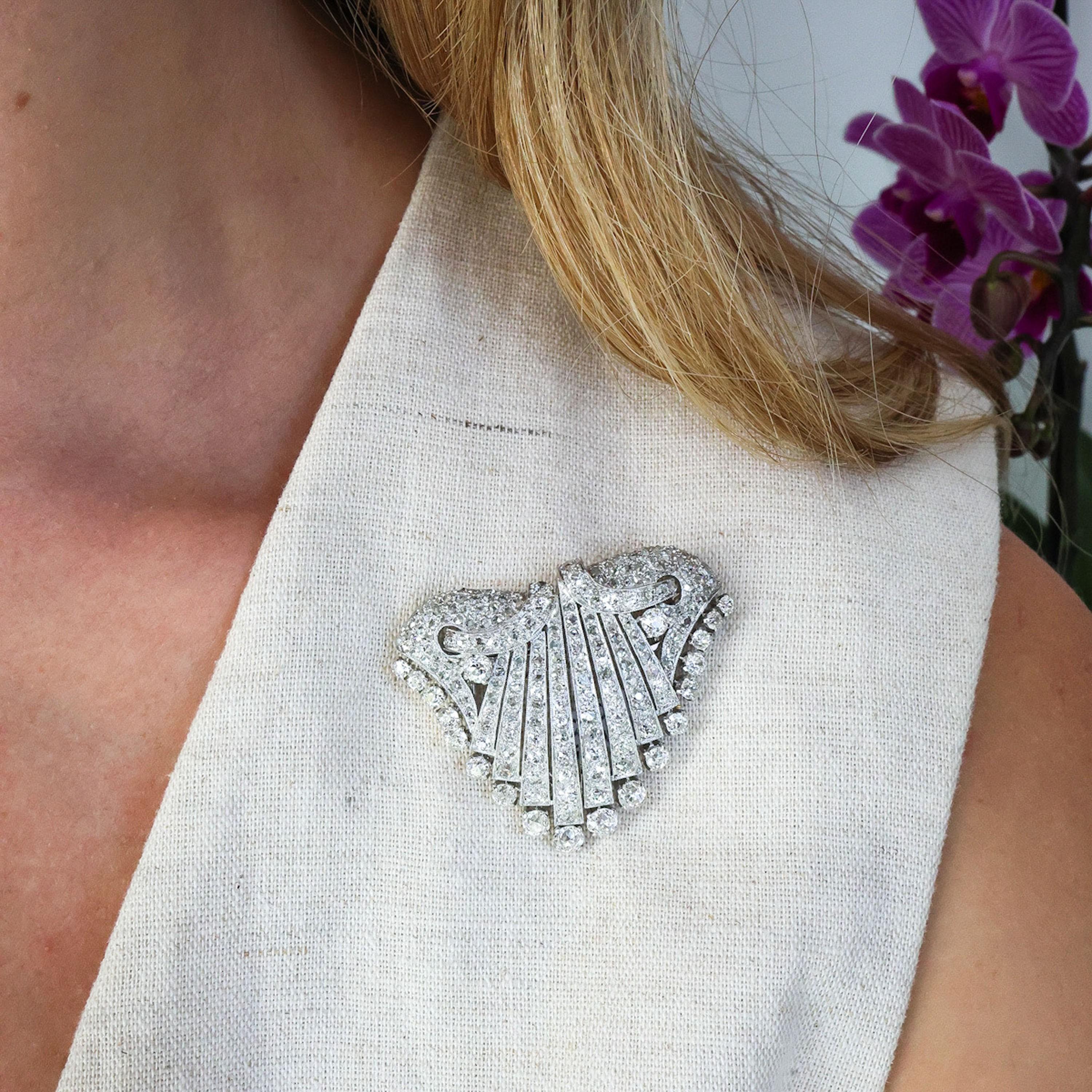 An Art Deco diamond and platinum double clip brooch, with pavé and grain set old-cut and rose-cut diamonds, in a stylised design of swags and folded fabric, fringed with old-cut diamonds, in four claw settings, mounted in platinum, with millegrain