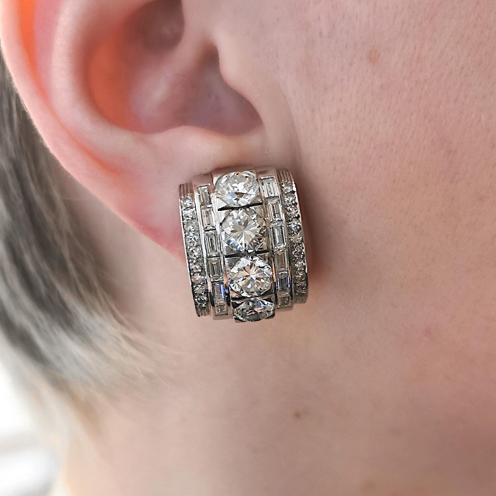 Ein Paar Art-Deco-Diamantohrringe, besetzt mit einer zentralen Reihe von Diamanten im Edwardian-Schliff, mit einer Reihe von Diamanten im Baguetteschliff auf beiden Seiten, mit rundem Brillantschliff,  und in der Umrandung eingefasste Diamanten im