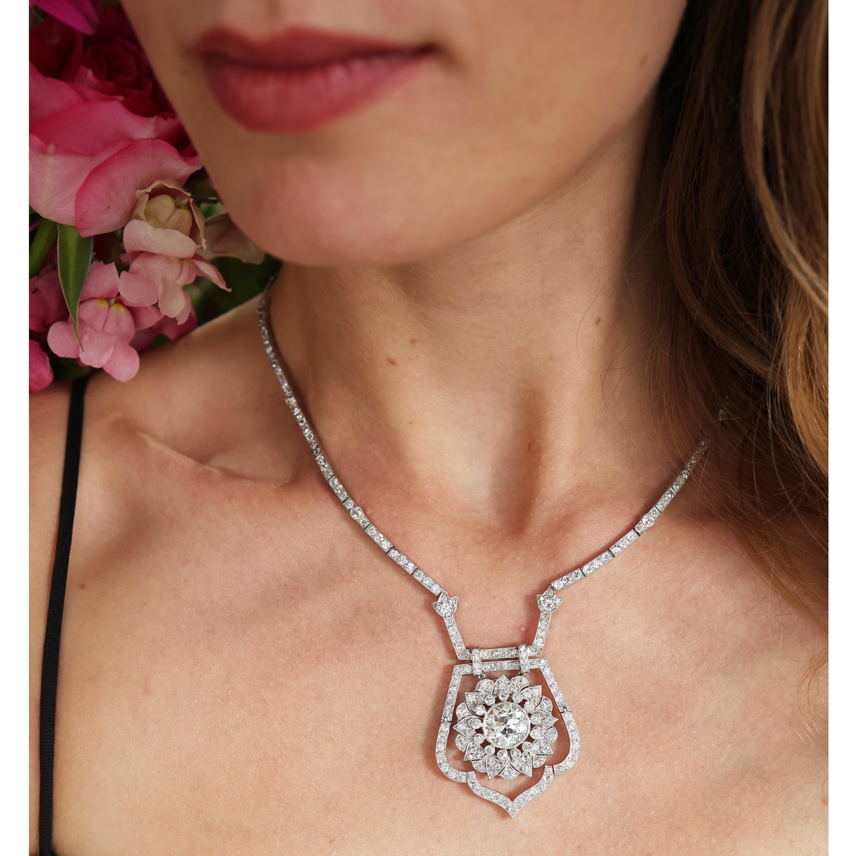 Una collana di diamanti Art Déco, disegnata con un diamante di taglio antico del peso stimato di 3,75 carati, incastonato al centro di un motivo floreale a grappolo e sospeso all'interno di un contorno articolato di diamanti di taglio antico,