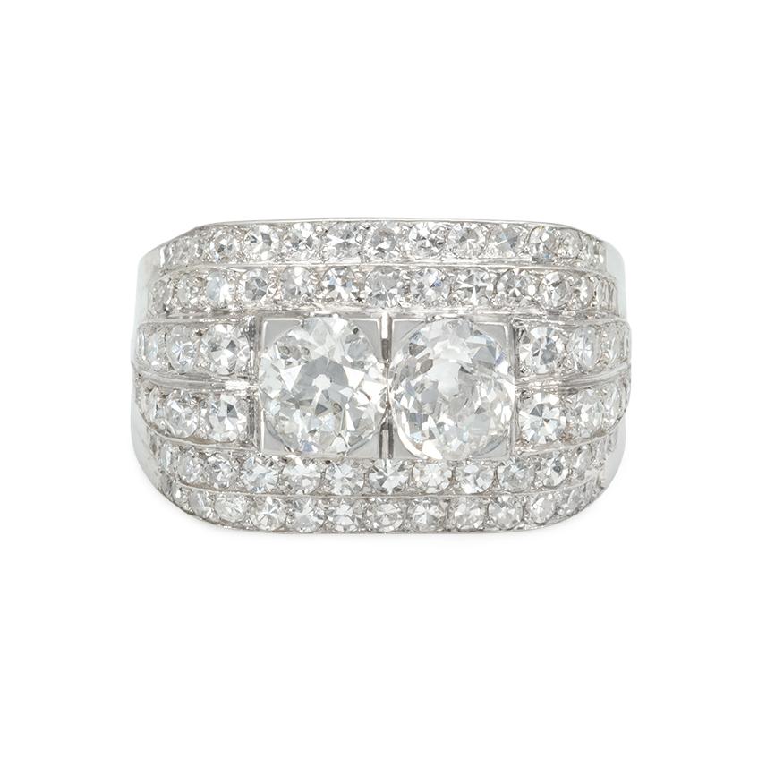 An Art Deco diamond ring of stepped design centering on two old-mine cut diamonds of approximately 0.53 ct. each, set in platinum with an openwork gallery  Argentina.  Atw 2.44 cts.  Face up dimensions: 1/2