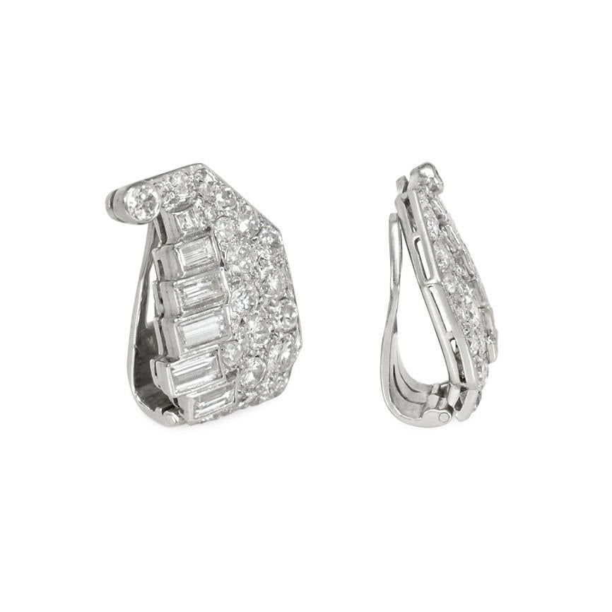 A pair of Art Deco diamond clip earrings of stylized cornucopia design set with round and baguette diamonds, in platinum.  Atw 1.62 ct.