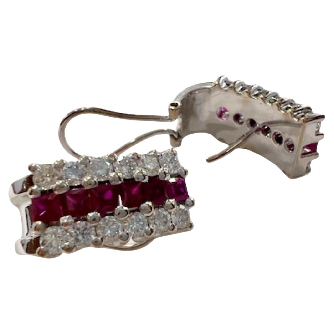 These Art Deco earrings are crafted in 18K gold and feature diamonds and rubies. They weigh 13.9 grams. The earrings include 24 brilliant-cut diamonds, totaling 2.00 carats, with VS clarity and G-H color. 
They also feature 12 princess-cut rubies,