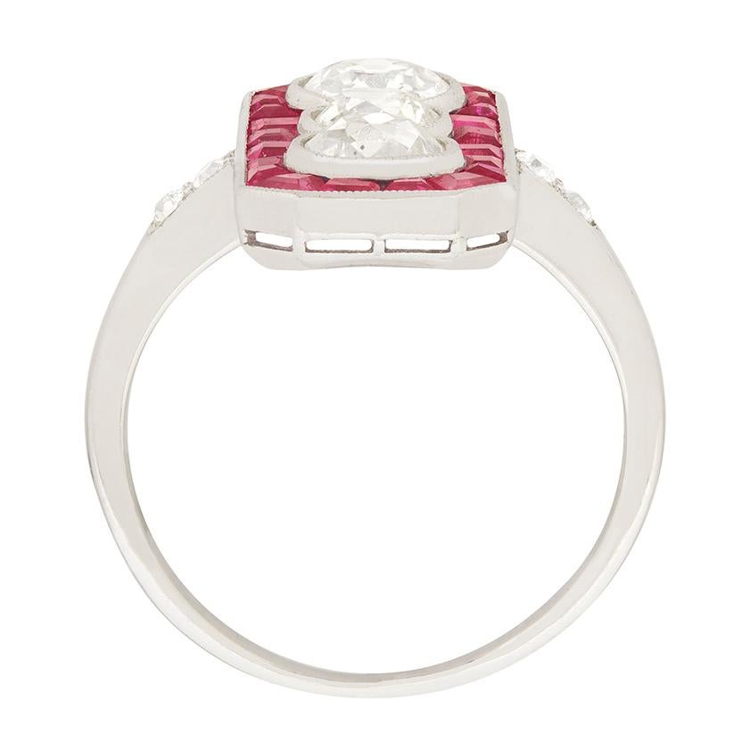This stunning art deco ring is has three diamonds, vertically set and perfectly haloed by french cut rubies. The three diamonds have a combined weight of 1.95 carat, the top diamond is 0.80 carat, the centre stone 0.50 carat and the bottom diamond