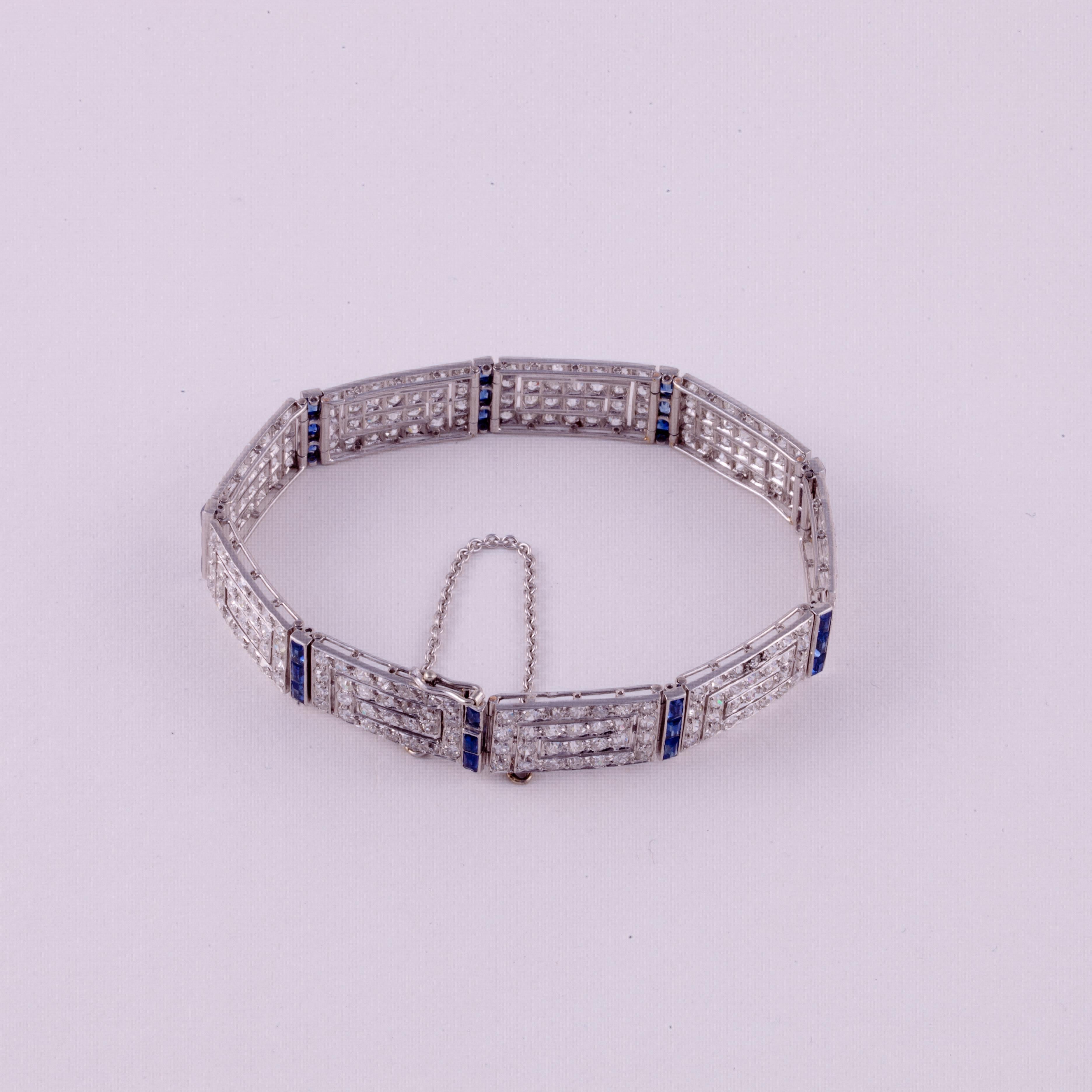 Art Deco bracelet in platinum, 18K white gold, diamonds and accented with blue sapphires. The links are elongated Greek Keys set with diamonds and sapphire bars in between each link.  There are a total of twenty-seven (27) calibré-cut sapphires 