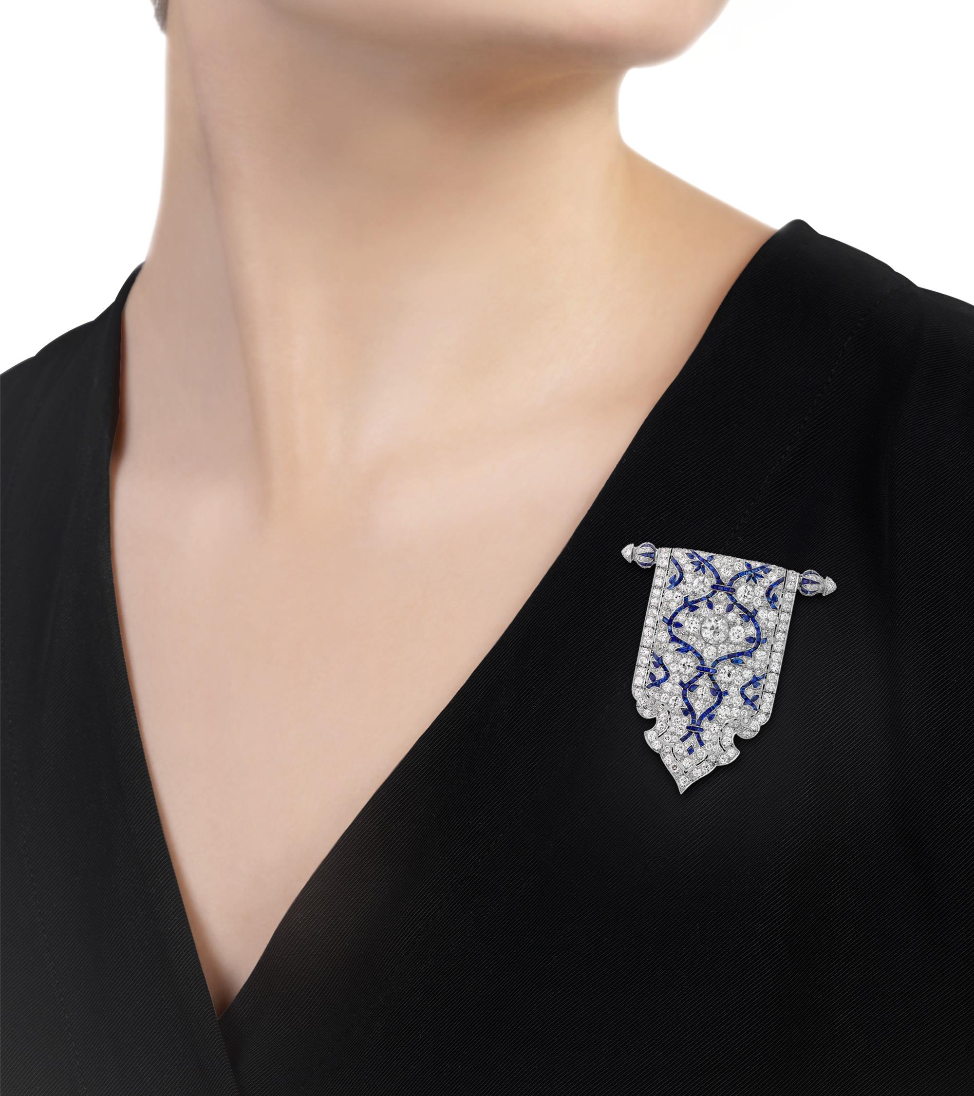 Exuding the glamour of a bygone era, this exceptional Art Deco brooch features expertly set white diamonds and sapphires. The royal blue gems line delicate foliate motifs across the pin, while the large central diamond, weighing approximately 0.75