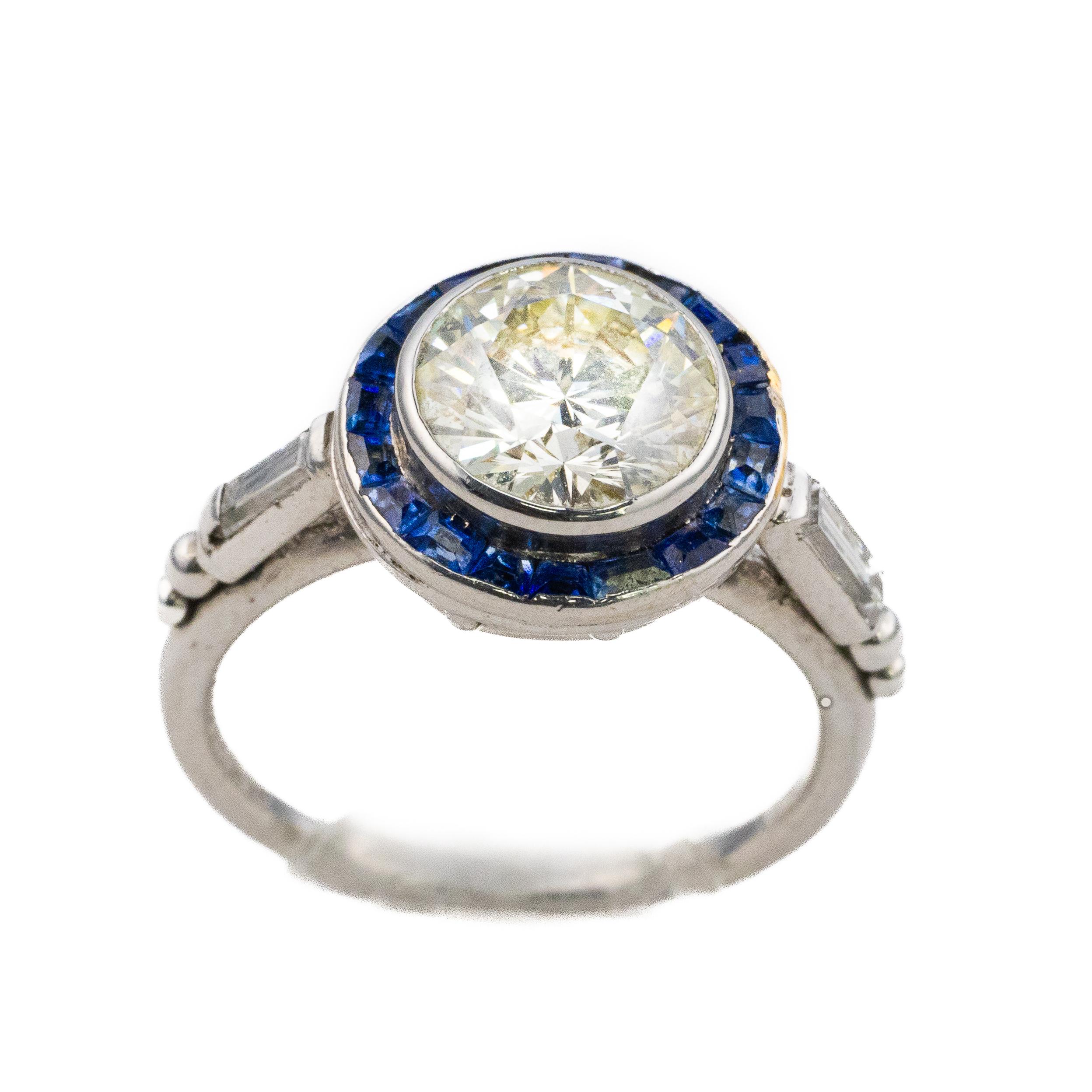 Bague Art déco à halo de diamants et de saphirs

Description :
Cette remarquable bague d'inspiration Art déco est centrée sur un diamant rond de taille brillant, encadré d'un saphir calibré en halo dans le style classique d'une bague cible. Le