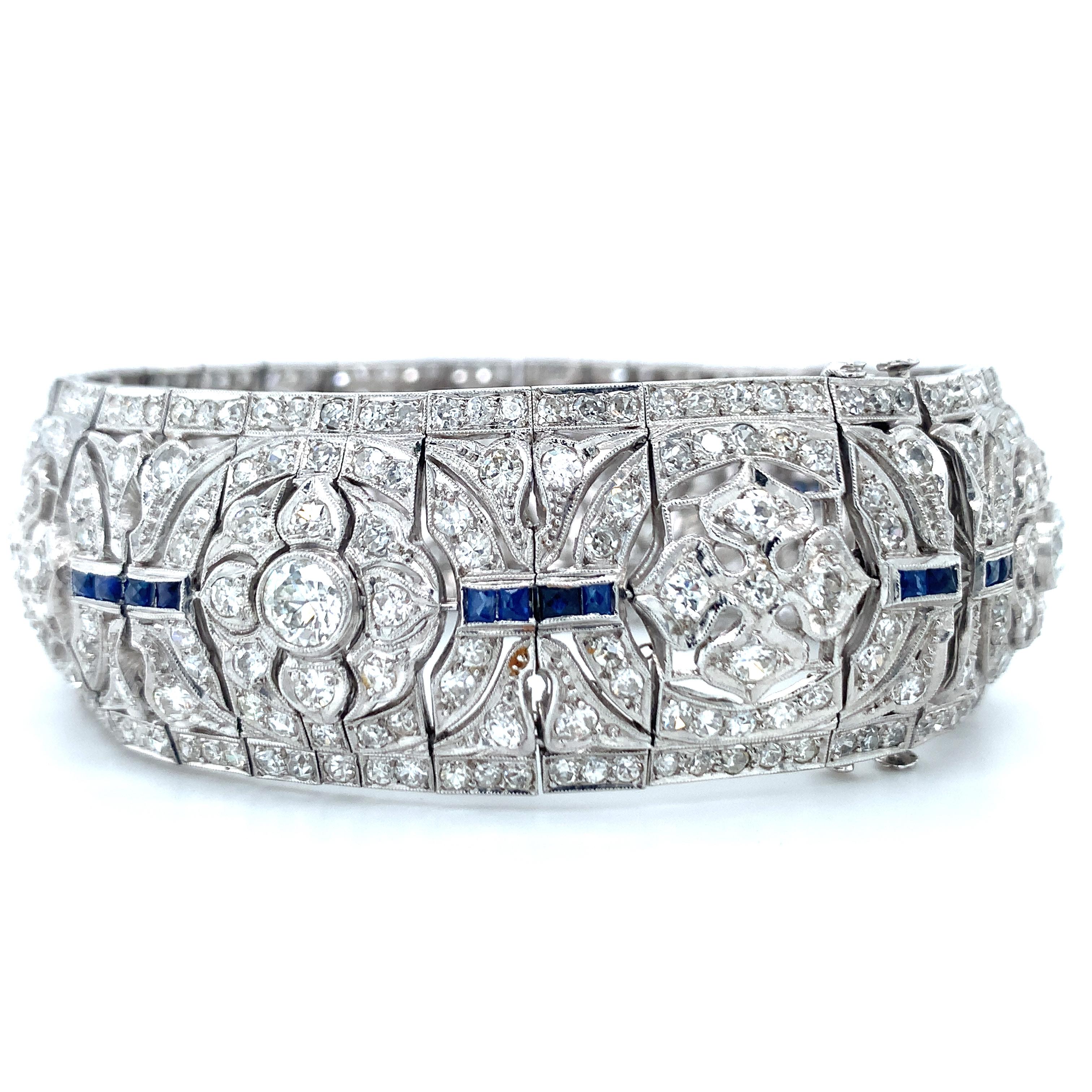 One Art deco wide strap diamond and sapphire bracelet handmade in platinum featuring 408 old European cut and single round cut diamonds totaling 16.44 ct. with H-I-J color and SI-1 clarity. The bracelet is enhanced by 32 French cut, sapphire accents