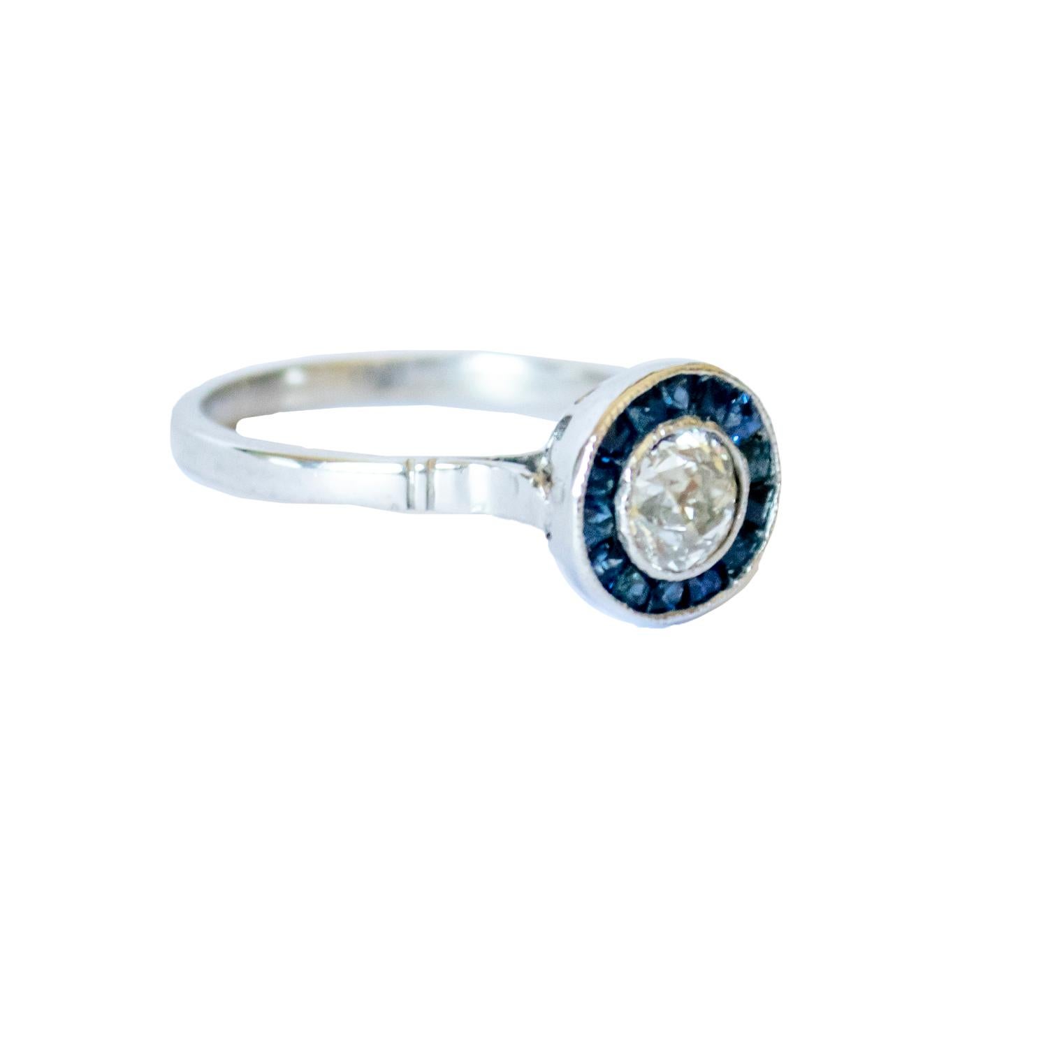 This Art Deco-style ring is crafted in platinum 950 and features diamonds and sapphires.
 It has a weight of 4.08 grams. 
The ring is adorned with one antique-cut diamond, weighing 0.56 carats, with SI1-SI2 clarity and H-G color. There are also 15