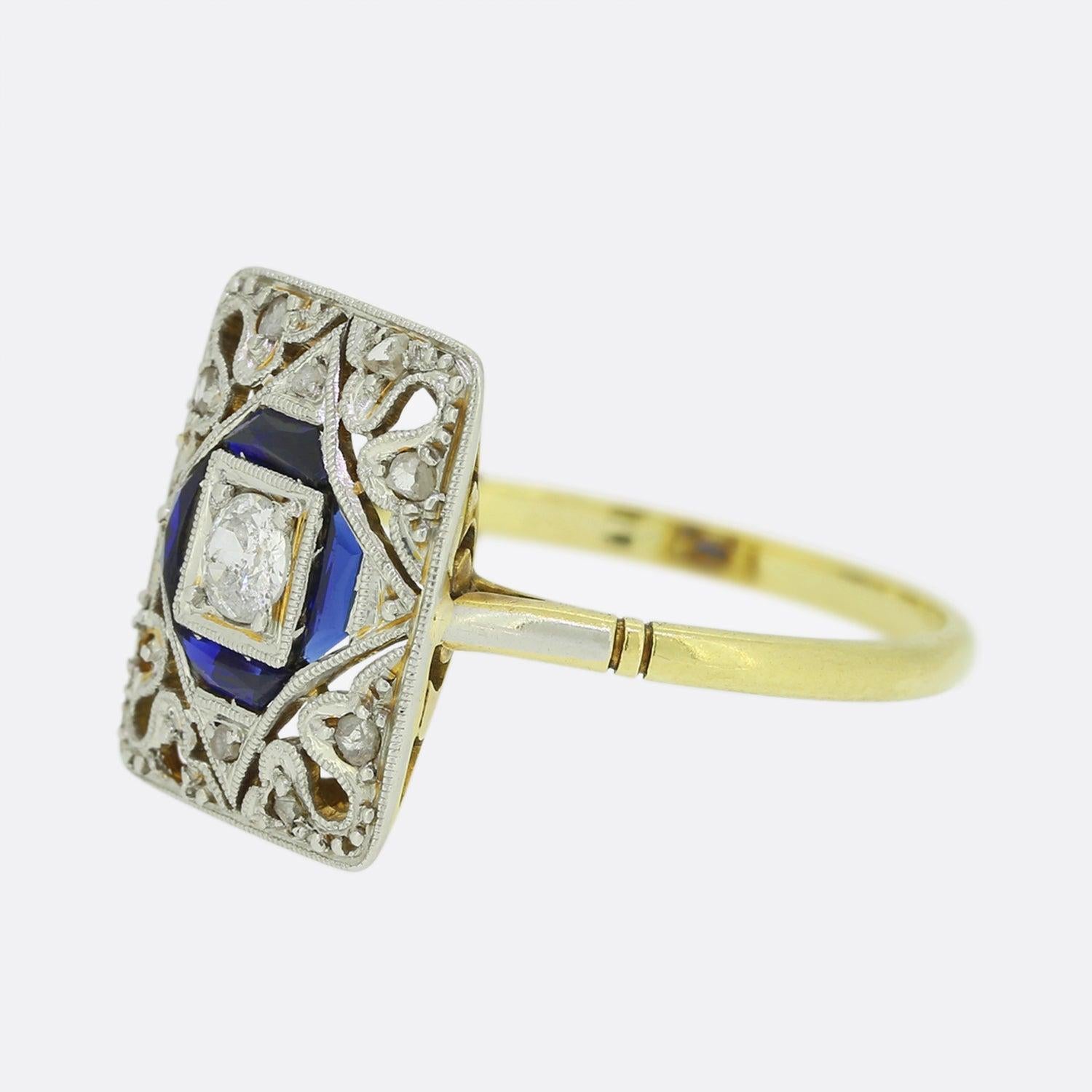 This is a wonderful Art Deco sapphire and diamond tablet ring. The ring showcases a central old European cut diamond that is surrounded by a border of trapezoid cut sapphires. The ring has been crafted in a rectangular shaped tablet setting crafted