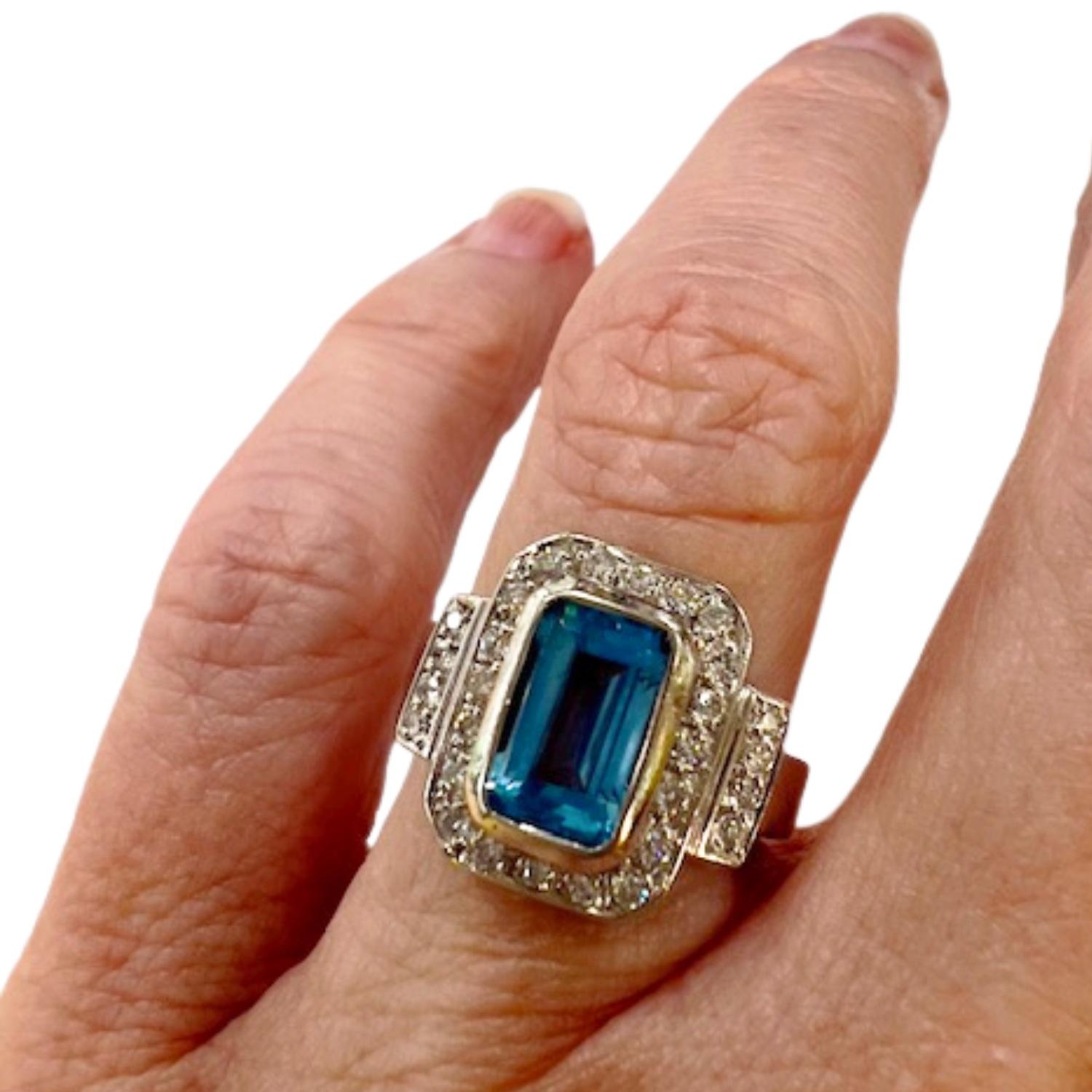 This  Art Deco 18 kts gold ring features in diamonds and a topaz. It weighs 7.48 grams and is sized ES 9 / EU 49 / US 4.75. The ring includes 29 brilliant-cut diamonds, totaling 0.58 carats, with VS clarity and G-H color. It also features a blue