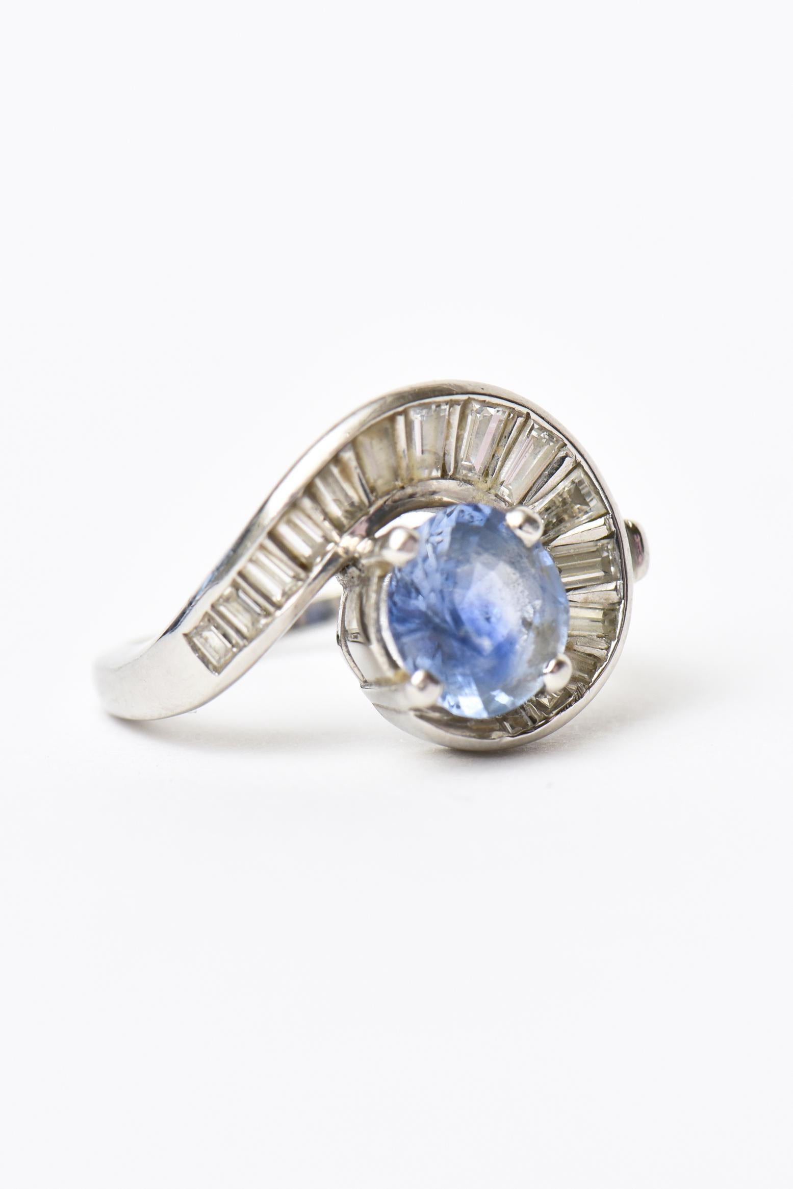 This lovely art deco ring has swirls of diamond baguettes that are 3/4 of a carat surrounded by light blue sapphire. It is all set in platinum. The sapphire stone is 1.85 carat. The ring is 5 DWT. It is a size 6. Platinum rings are more collectable