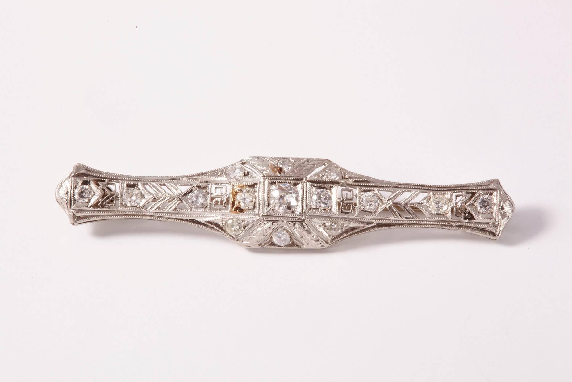 An Art Deco Diamond Bar Brooch, set with old-cut diamonds, one larger center stone, surrounded with millegrain and diamonds. The center design incorporates Greek Key edging with beautiful, clean craftsmanship.
Art Deco mounted in platinum-upon-gold.