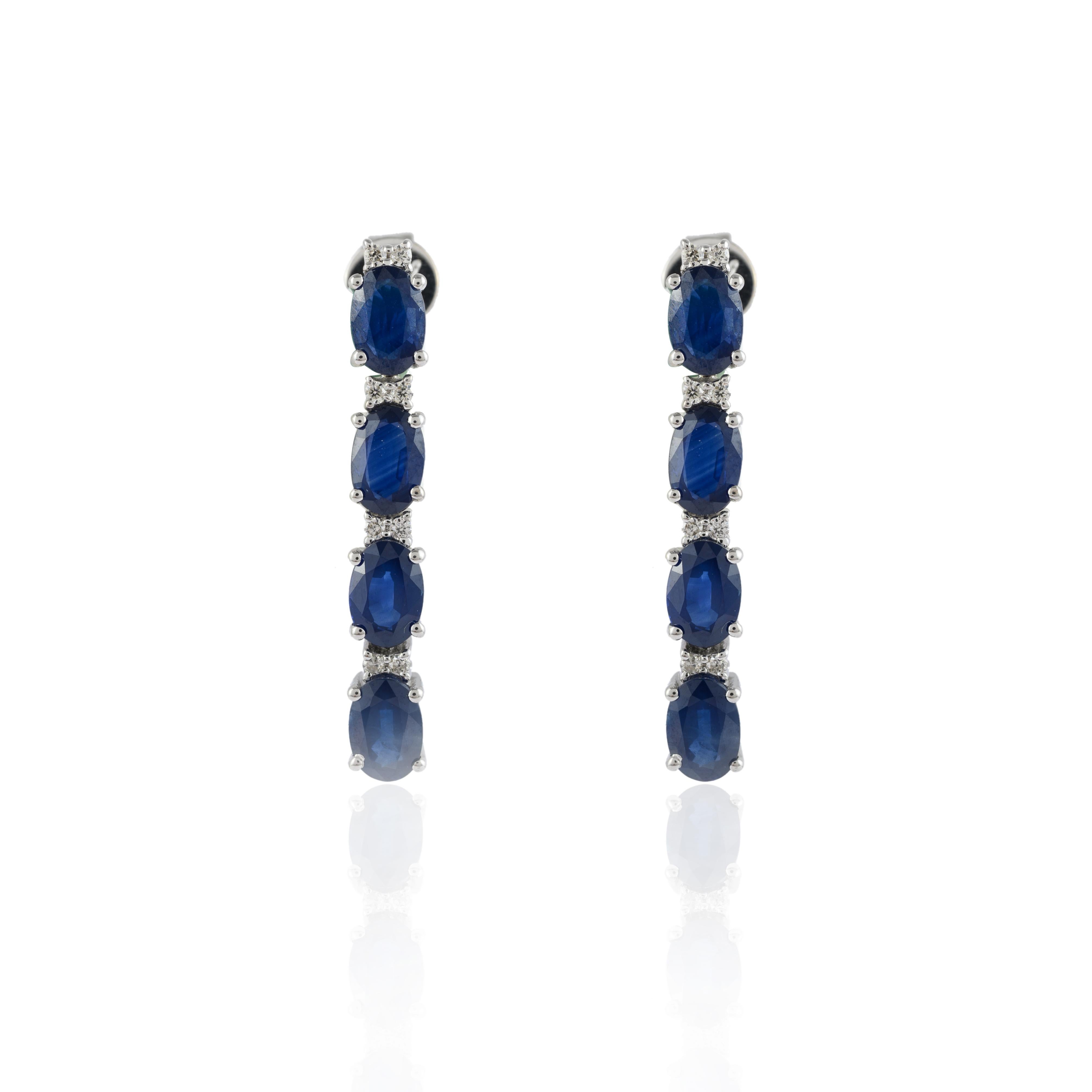 Diamond blue sapphire dangle earrings in 14K gold to make a statement with your look. These earrings create a sparkling, luxurious look featuring oval cut gemstone.
Sapphire stimulates concentration and reduces stress. 
Designed with alternate oval