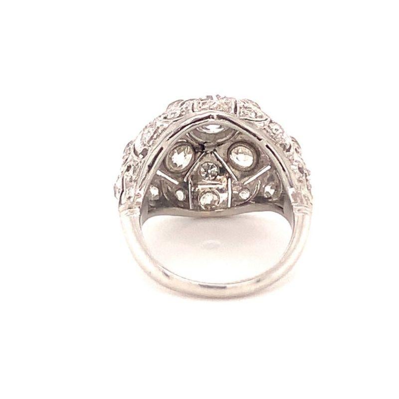 One Art Deco diamond bombe platinum ring with pierced motif design featuring 25 bead and bezel set, old European cut and old mine cut diamonds totaling 3 ct. with I-J color and VS-2 clarity. The ring measures 18 x 21 millimeters in size across the