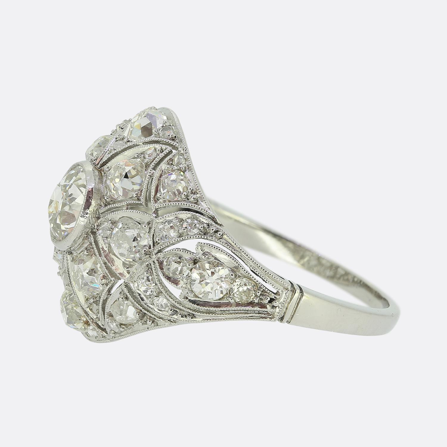 Ecco uno splendido anello con bombe di diamanti realizzato durante l'apice del movimento Art Déco. Al centro della faccia troviamo un singolo diamante rotondo sfaccettato di vecchia miniera. Questa pietra principale si trova da sola e orgogliosa in