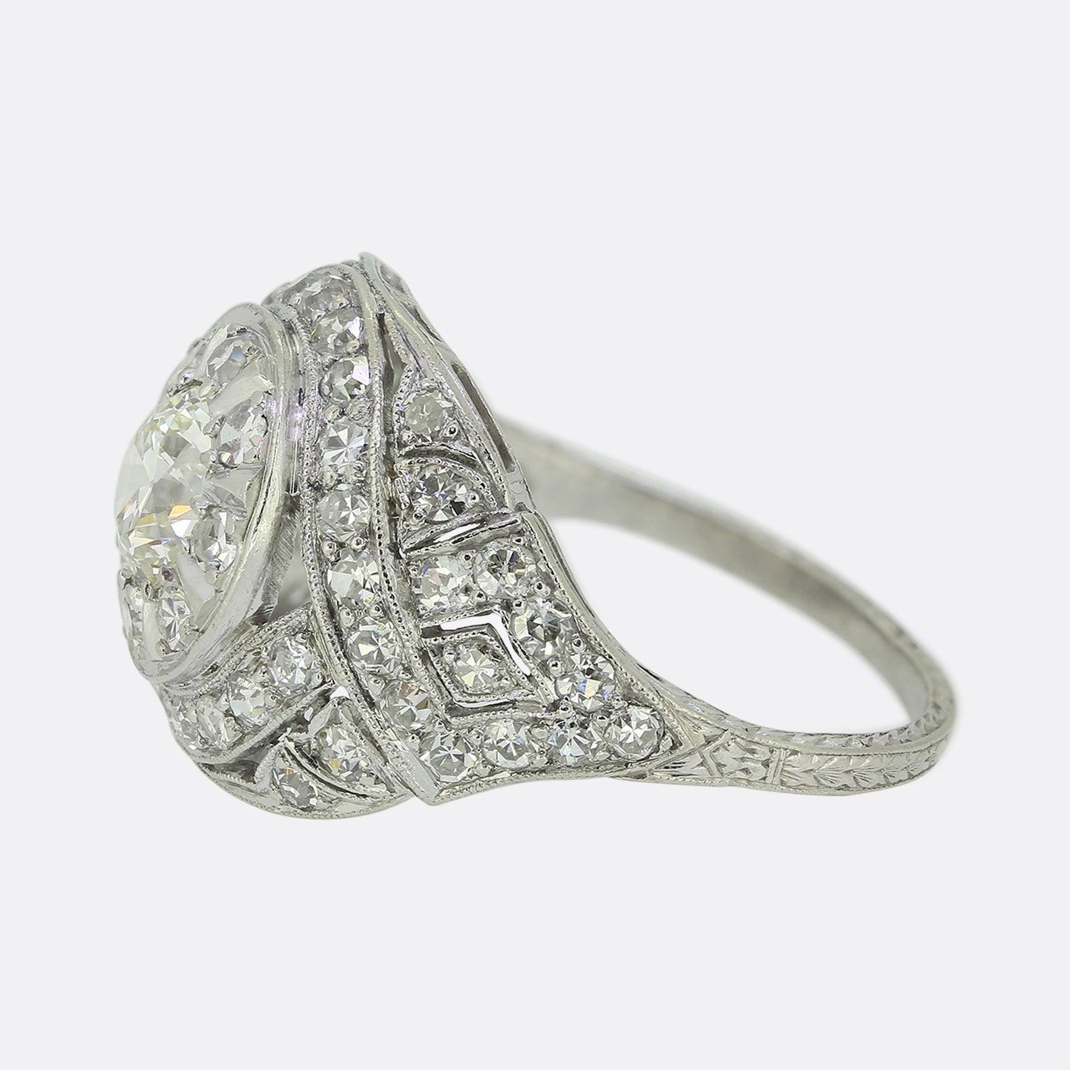 Here we have a scintillating Art Deco diamond bombe ring crafted at the height of the style's original popularity in the 1920s. The piece features a single round faceted old cut diamond which sits proud at the centre of the face and is framed by a