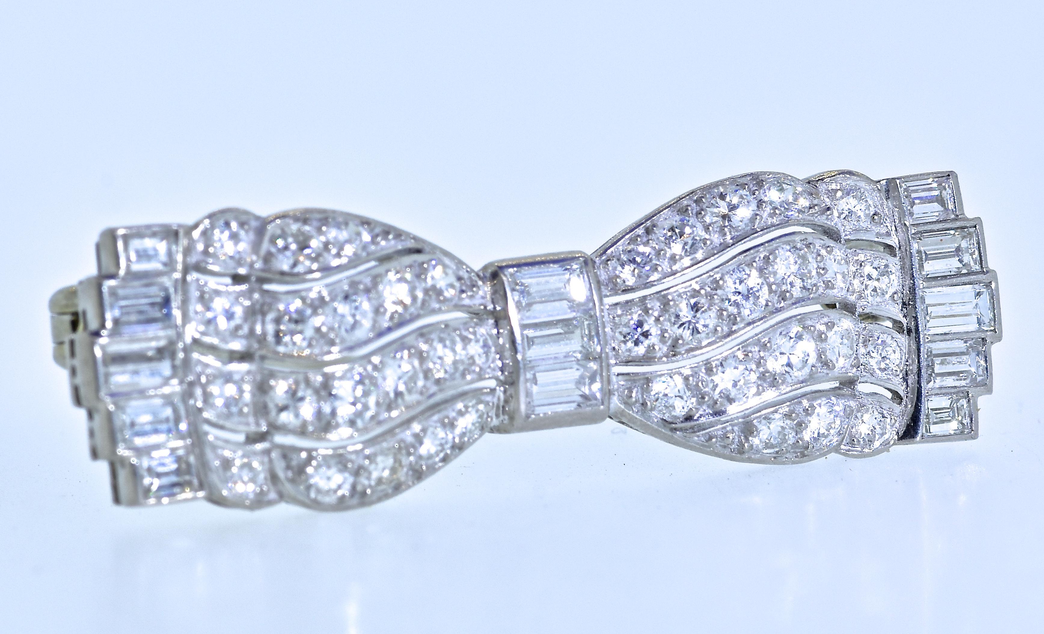 Art Deco brooch in the motif of a bow-tie.  This small masterpiece possesses an estimated 1.50 cts of very fine white diamonds.  There are 51 diamonds, 38 round brilliant cut and 13 long baguette cut diamond.  All the stones are well cut, well set