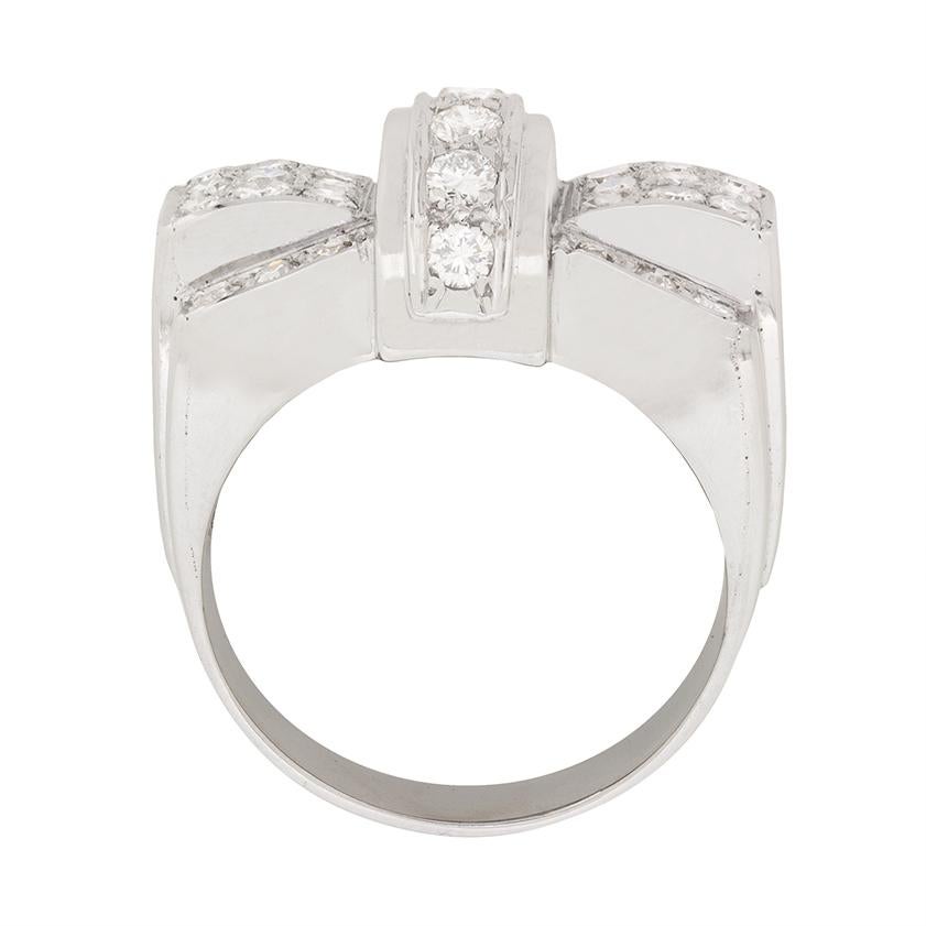 This unique cocktail ring is perfect for that special occasion. It features a bow design, with a strand of vertically set diamond in the centre, which are round brilliant. They are grain set which compliments the grain set eight cuts on either side.