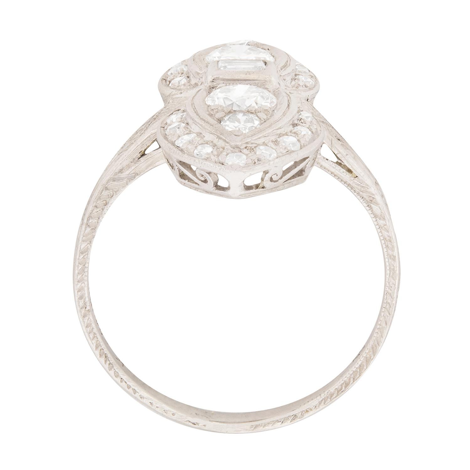 This elegant art deco ring features 1.06 carats of old cut and baguette diamonds. Intricate in design, two 0.30 old cut diamonds are surrounded by smaller old cut diamonds in an arching pattern. The two arches centre around a baguette diamond. The